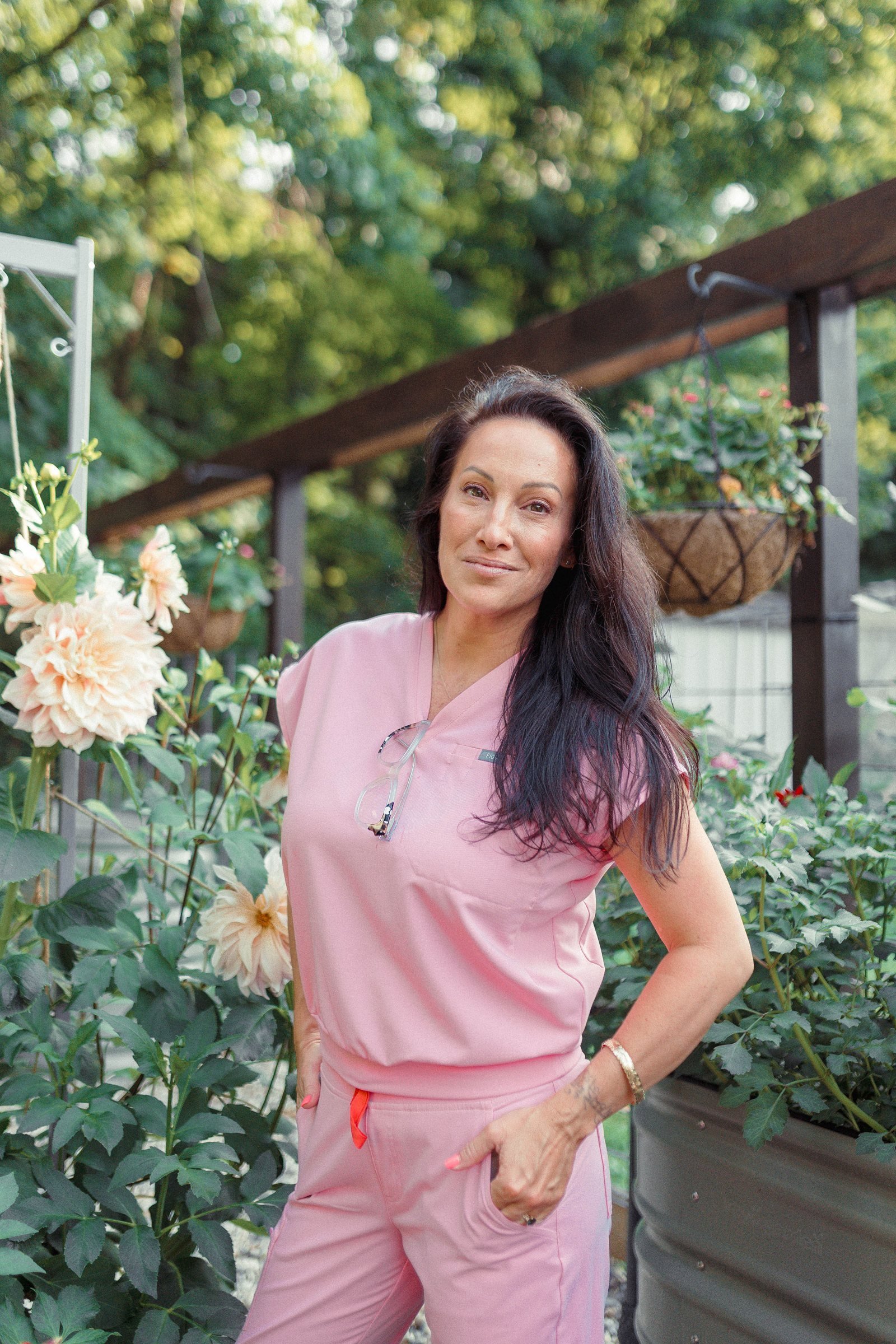 Dr. Siân West, OB-GYN and menopause specialist, in pink scrubs in her garden