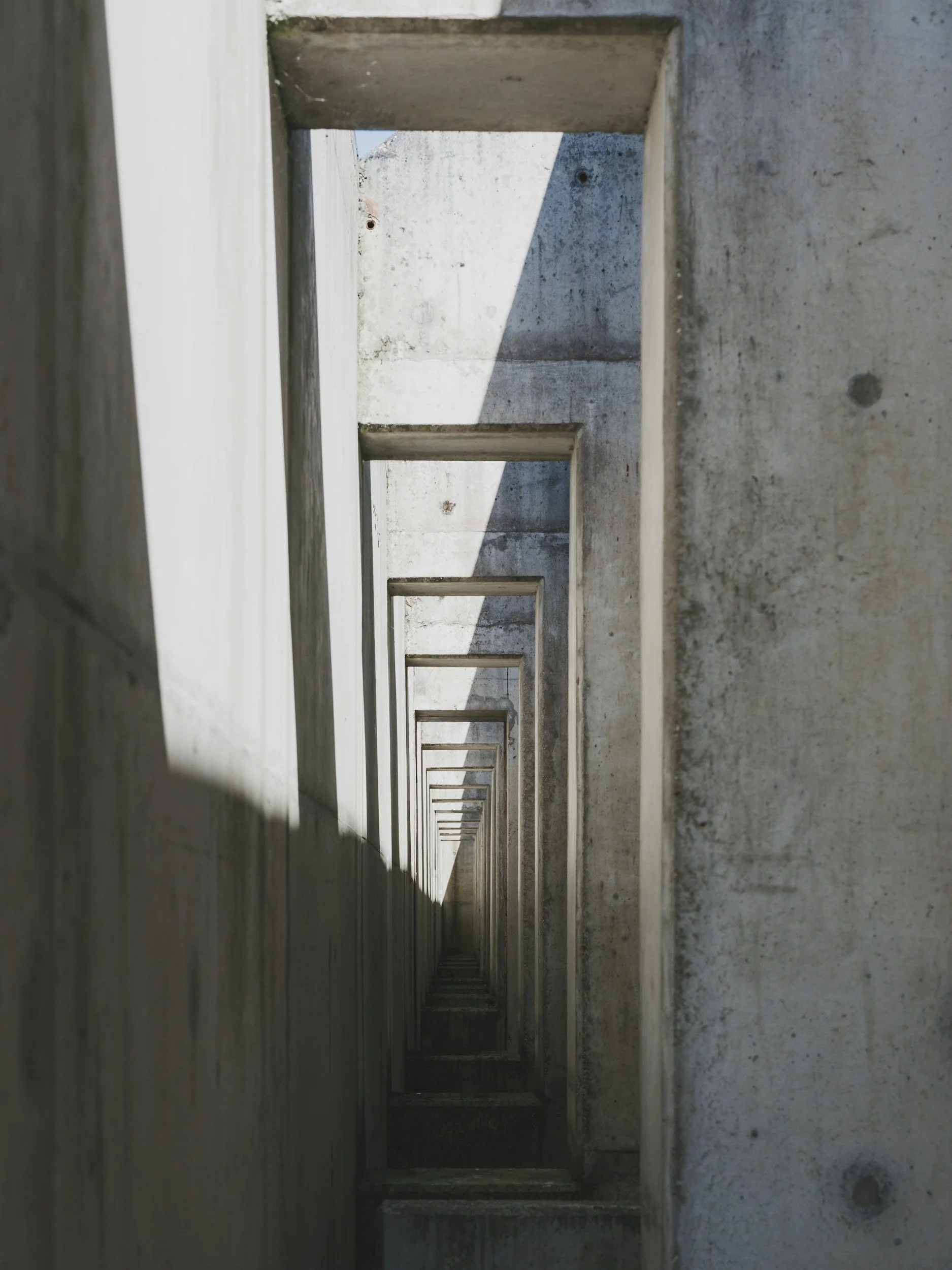 Striking geometric lines of a modern concrete staircase catching light and shadow, visually mirroring the balanced, built-to-last financial frameworks engineered for independent founders.