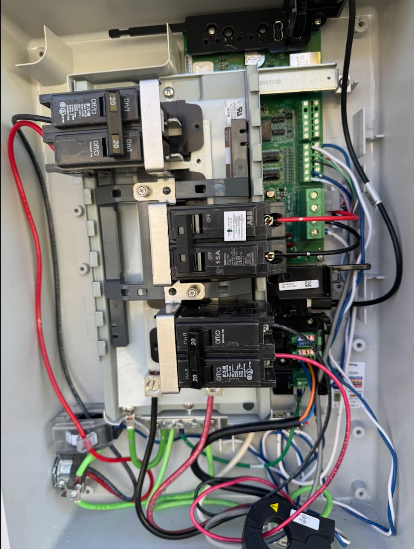 The interior of an electrical panel with various circuit breakers, wires, and a circuit board.