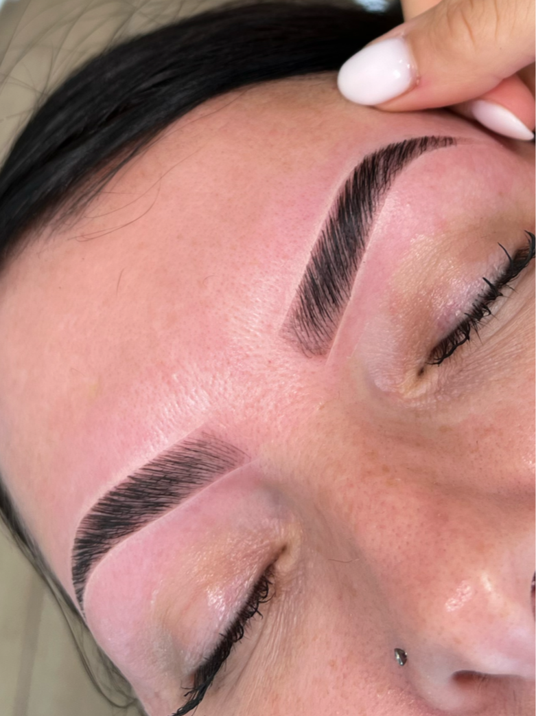 Close-up of a woman's face showing fresh, well-groomed, and defined eyebrows, with her eyes closed.