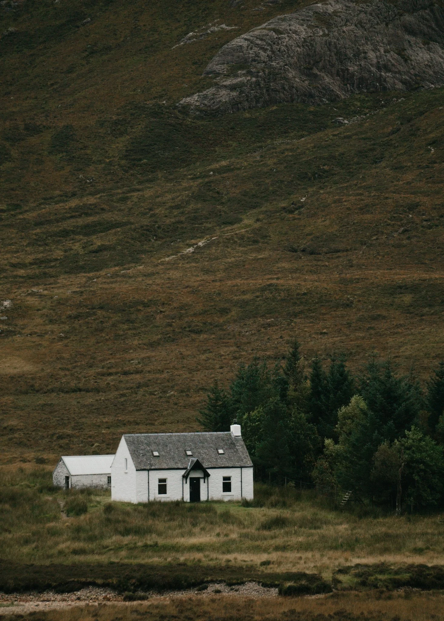 The iconic small white cottage nestled lonely at the base of the massive, imposing mountain slopes of Glencoe.