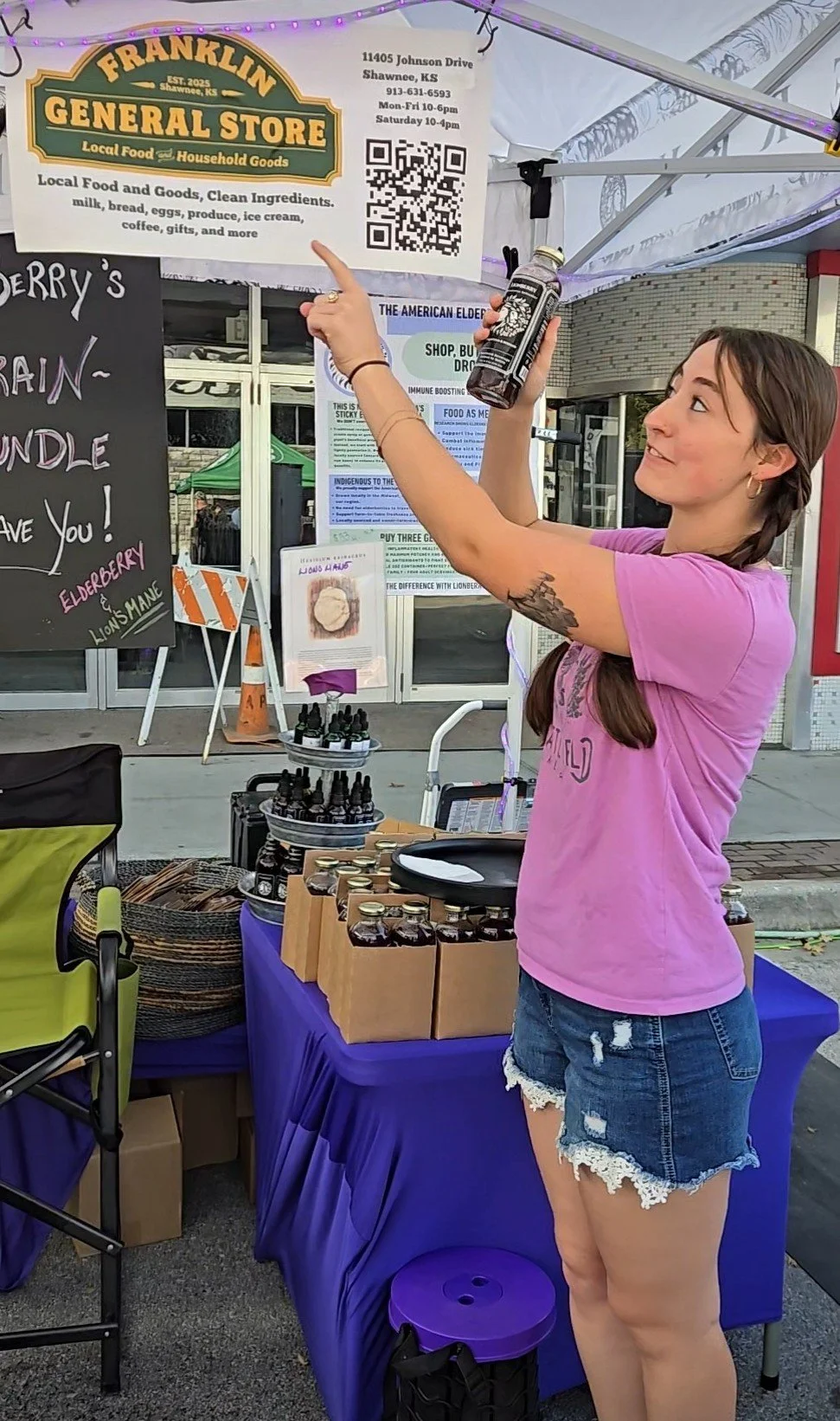 Vendor showcases locally produced elderberry products at a farmers market, highlighting direct-to-consumer sales, regional food systems, and growing market opportunities for American elderberry growers and value-added producers.
