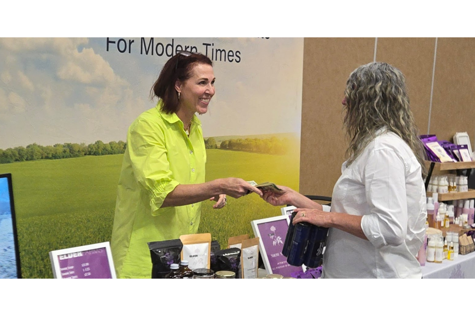 An American elderberry producer interacts with a customer at a product display, demonstrating how value-added elderberry products create market opportunities, strengthen local economies, and connect consumers with regional agriculture.