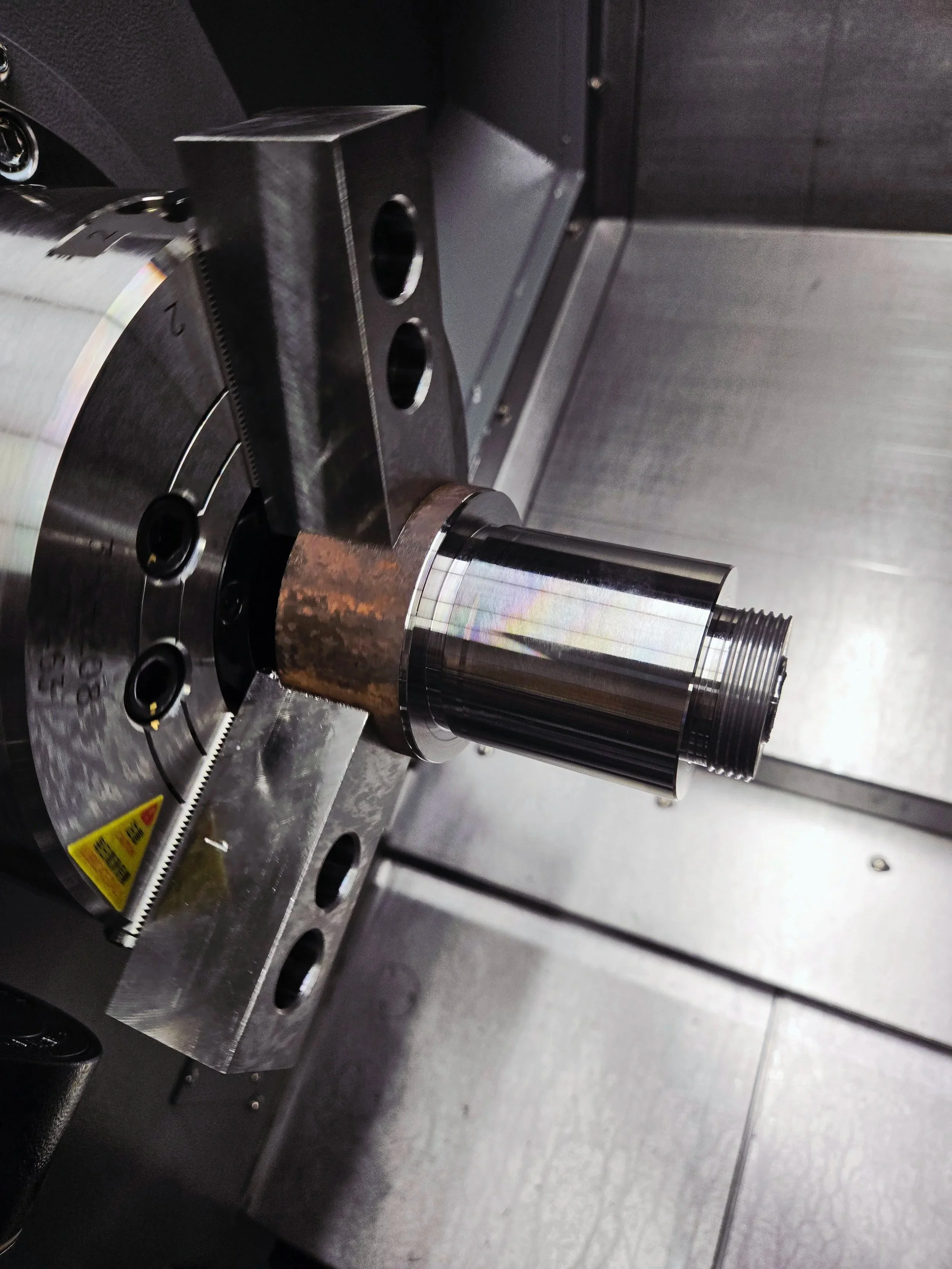 CNC turning operation machining a precision metal shaft on a CNC lathe for high-tolerance industrial components