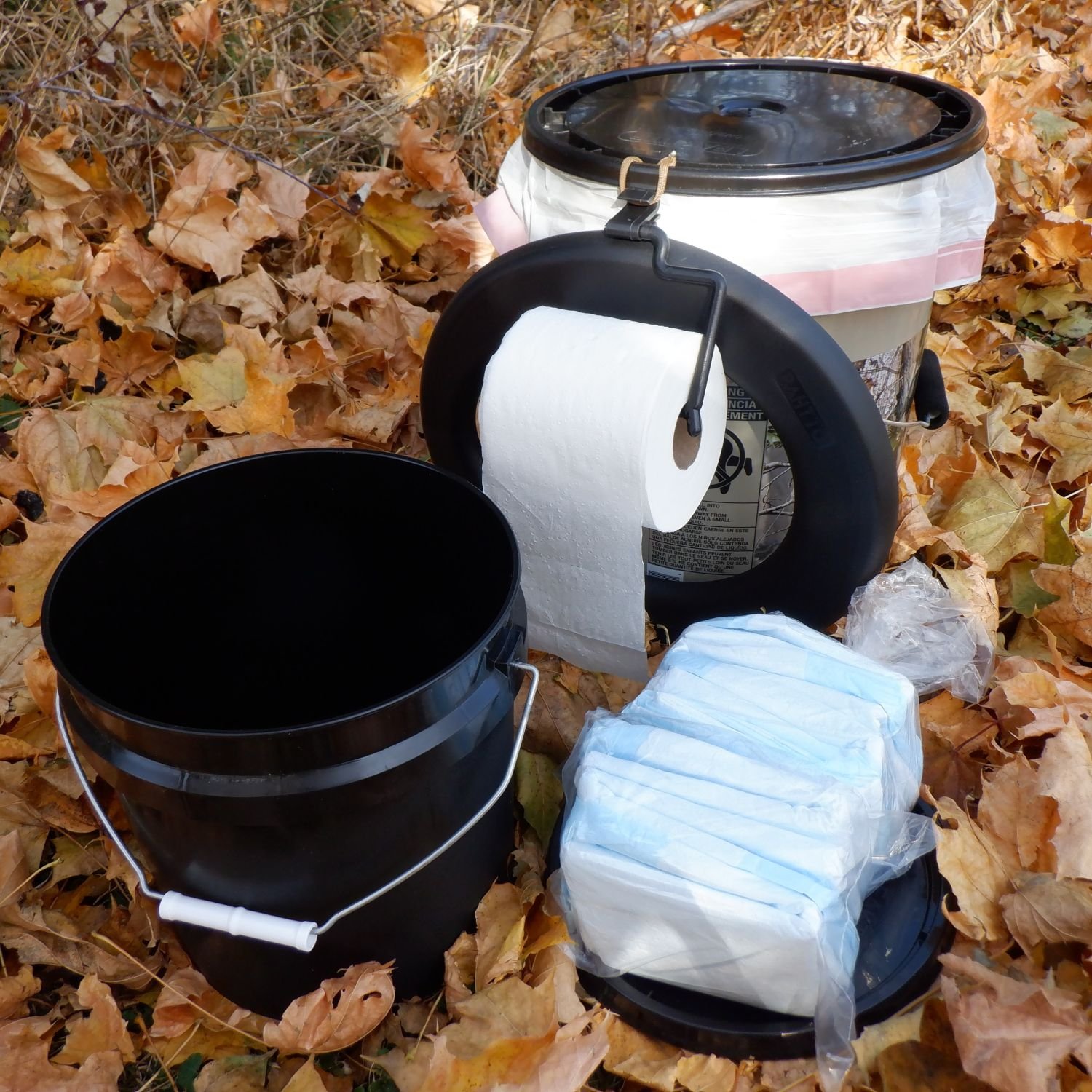 The Ejection Seat with 5 gallon camo bucket, toilet seat, small supply bucket, 8 absorbent cartridges, toilet paper hanger, and roll of toilet paper