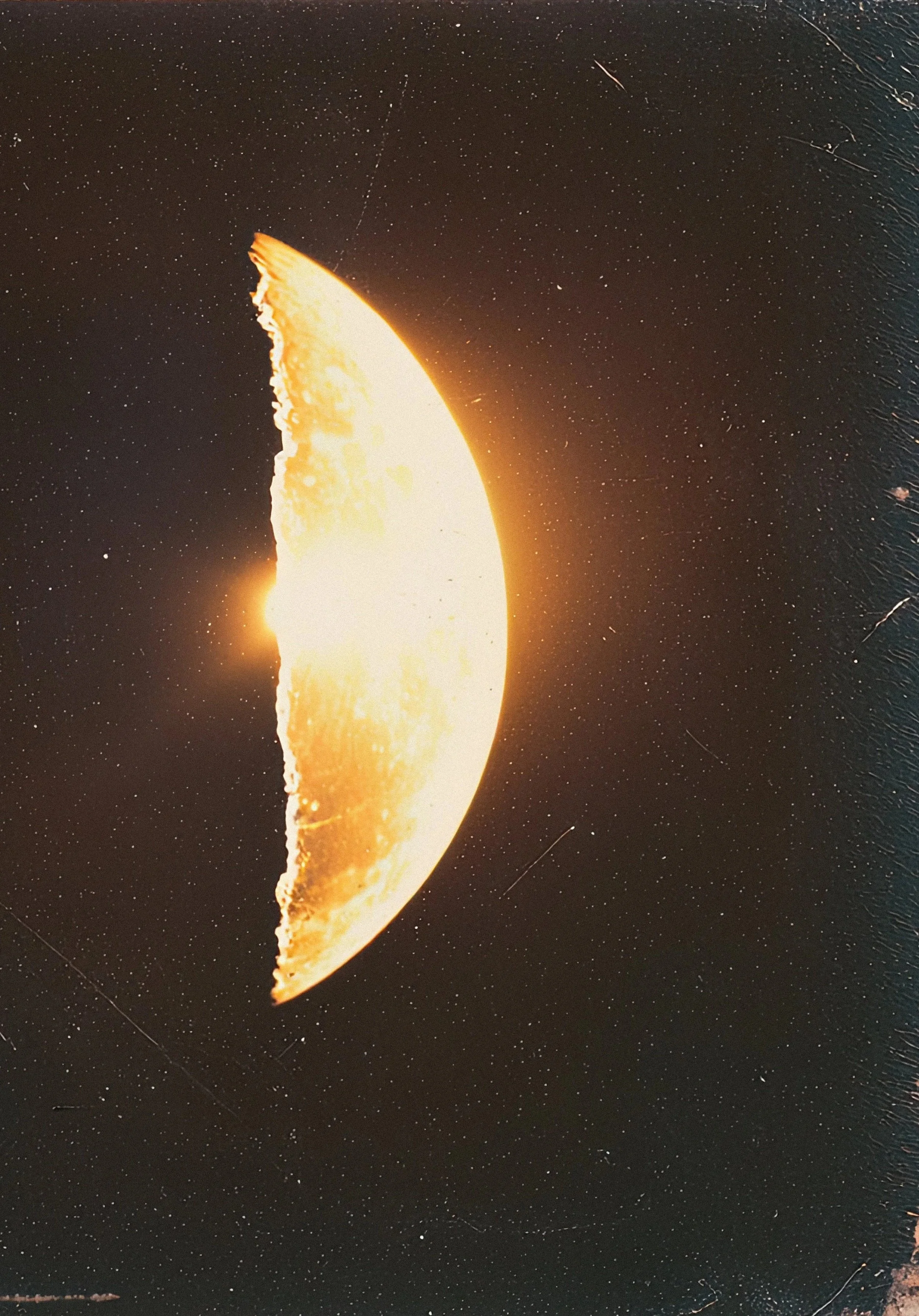 A partially visible moon in space with stars surrounding it.