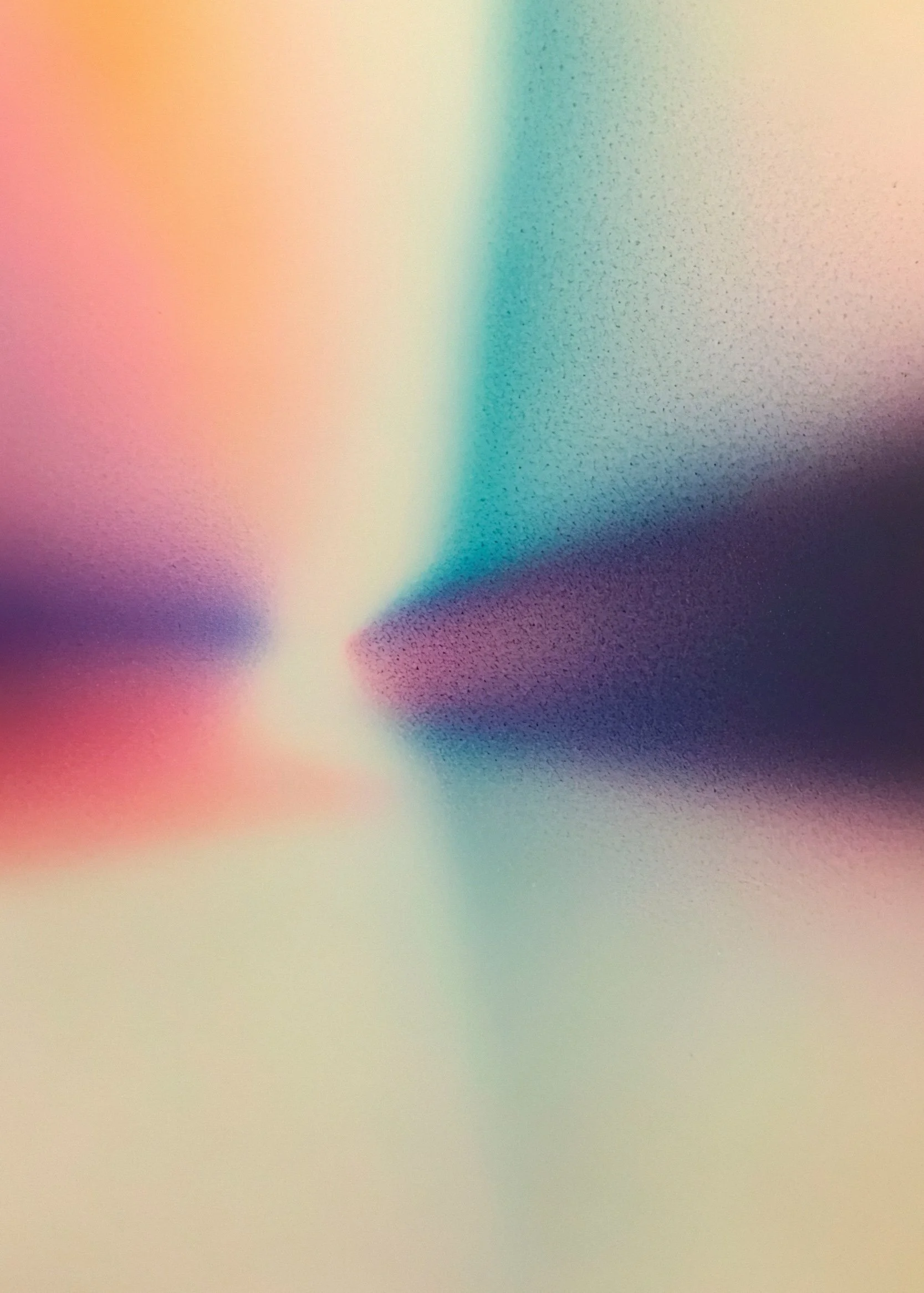 Abstract image with gradient colors blending from pink, orange, yellow to blue, purple, and black, with a soft focus and spray-paint-like texture.