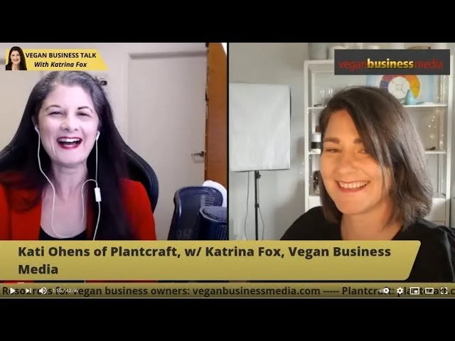 Split-screen video interview of two women discussing vegan business. The woman on the left has long dark hair, is smiling, wearing a red top, and in front of a plain background. The woman on the right has shoulder-length brown hair, is smiling, wearing a black top, and in a room with a bookshelf and a whiteboard. Text overlays indicate they are talking about vegan business and feature their names and affiliations.