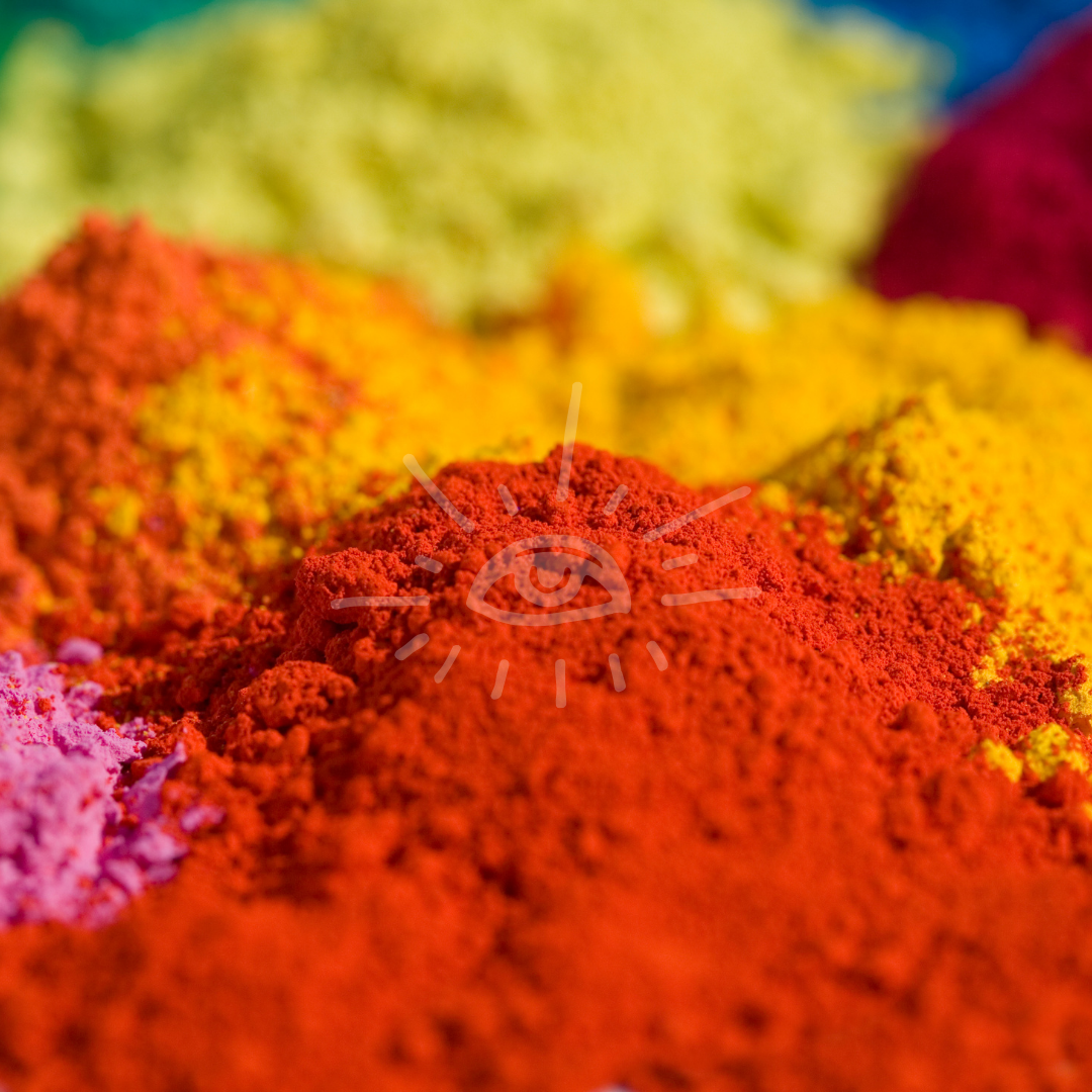 Close-up of colorful powders in red, orange, yellow, green, and pink, used for Holi festival.