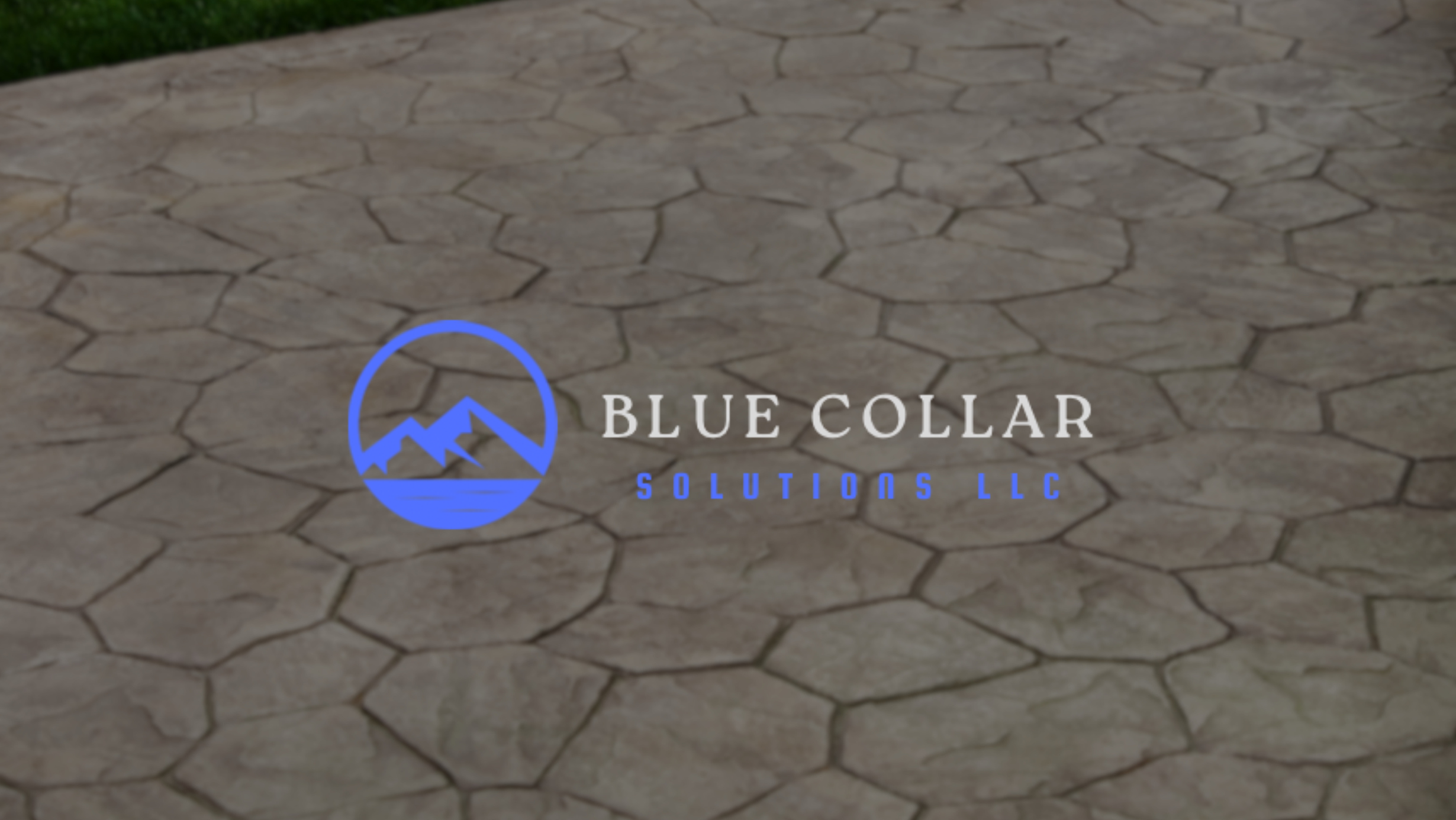 A stone walkway with a blue and white logo of a mountain and water, along with the text 'Blue Collar Solutions LLC' in white and blue.