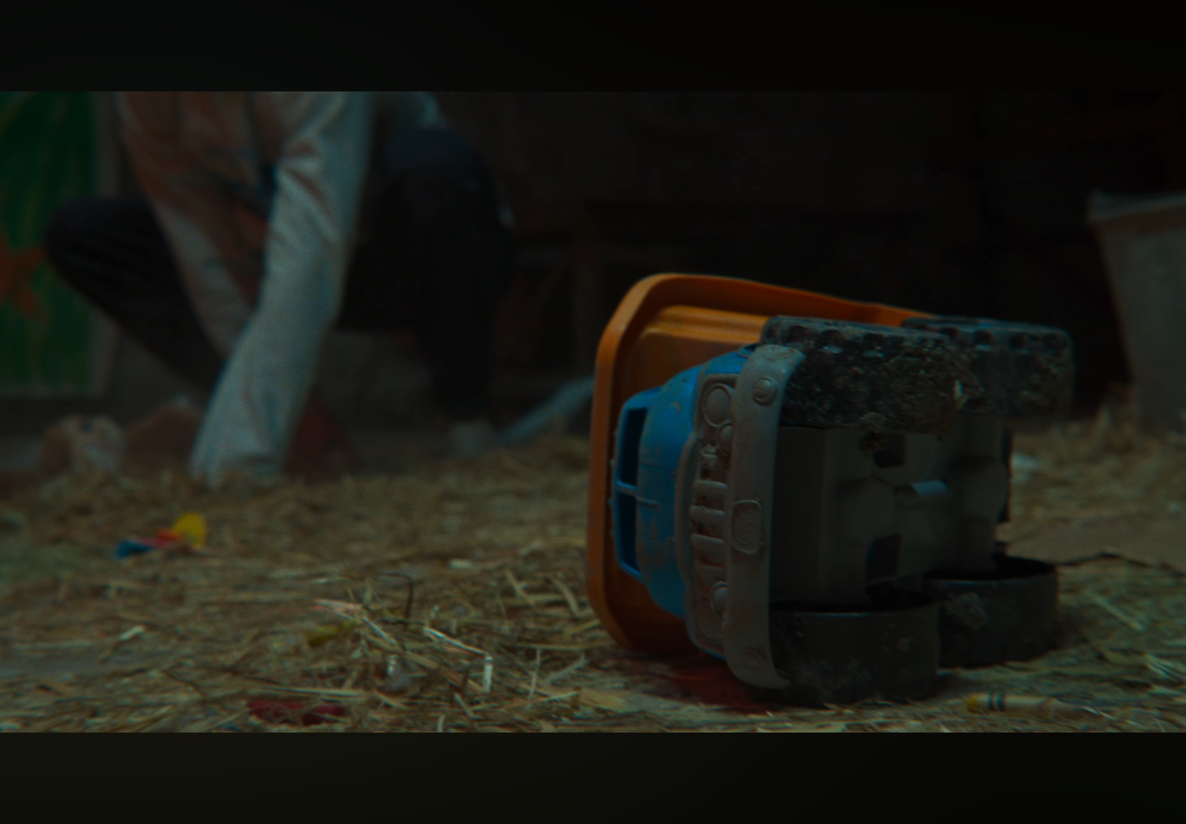 A toddler on the floor playing with a toy vehicle.