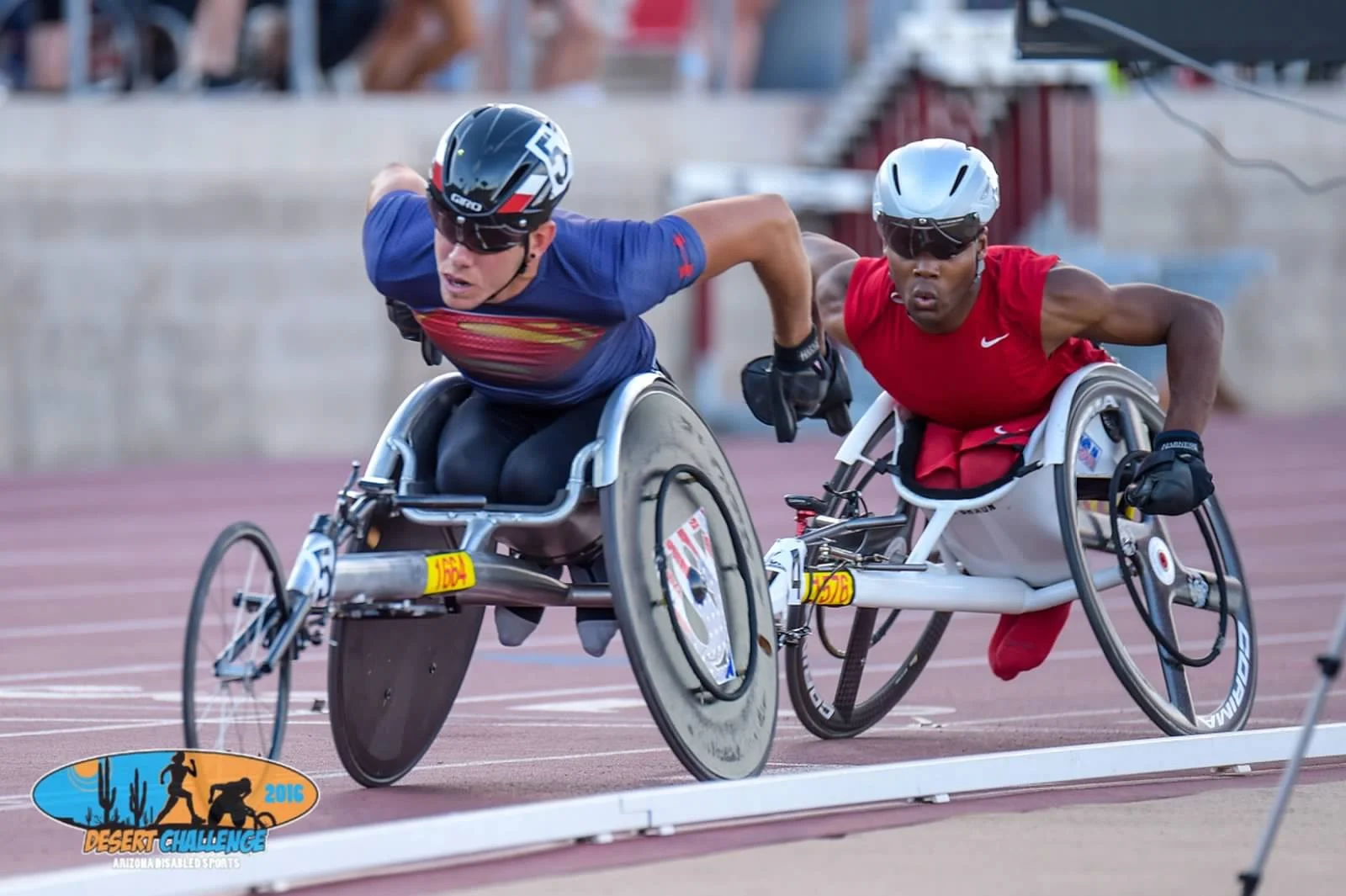 Two athletes in racing wheelchairs competing on a track during the 2016 Desert Challenge in Anza, California.