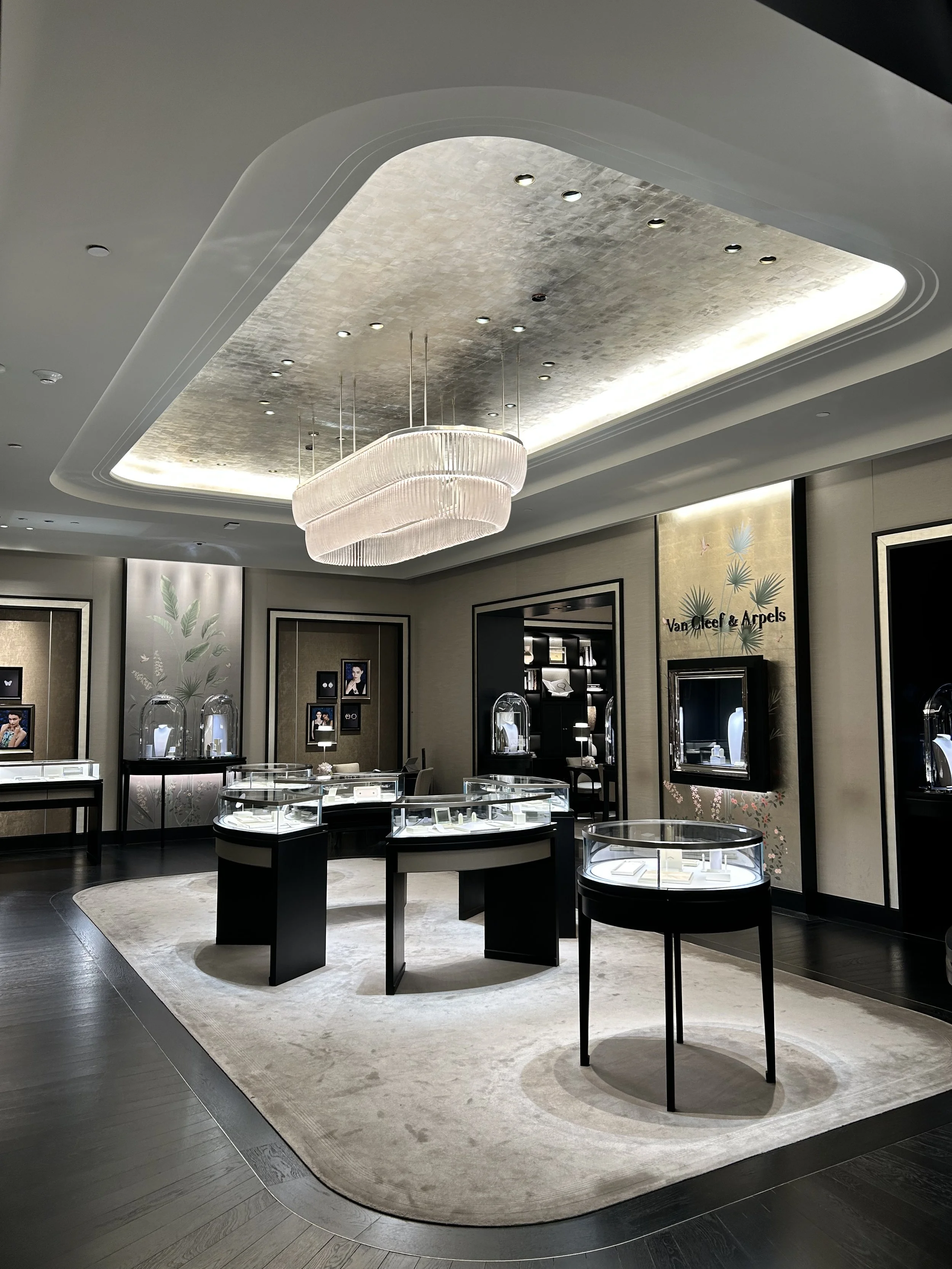 Luxury jewelry store interior with display cases, wall art, and elegant lighting fixtures.