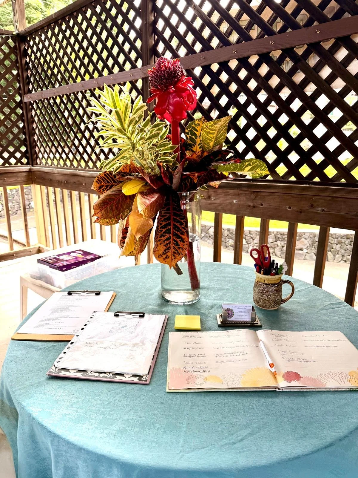 Meeting table with tropical flowers and planning notes at New Thought Center of Hawaiʻi