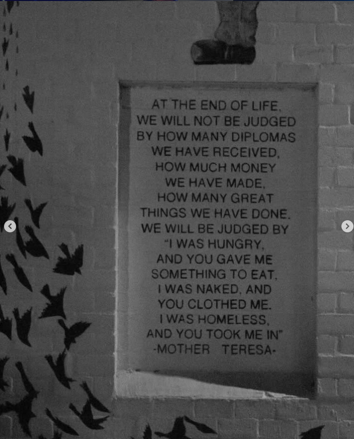 A quote on a plaque attached to a brick wall, referencing the perspective on judgment based on deeds, love, and compassion at the end of life on roosevelt row phoenix arizona during first friday