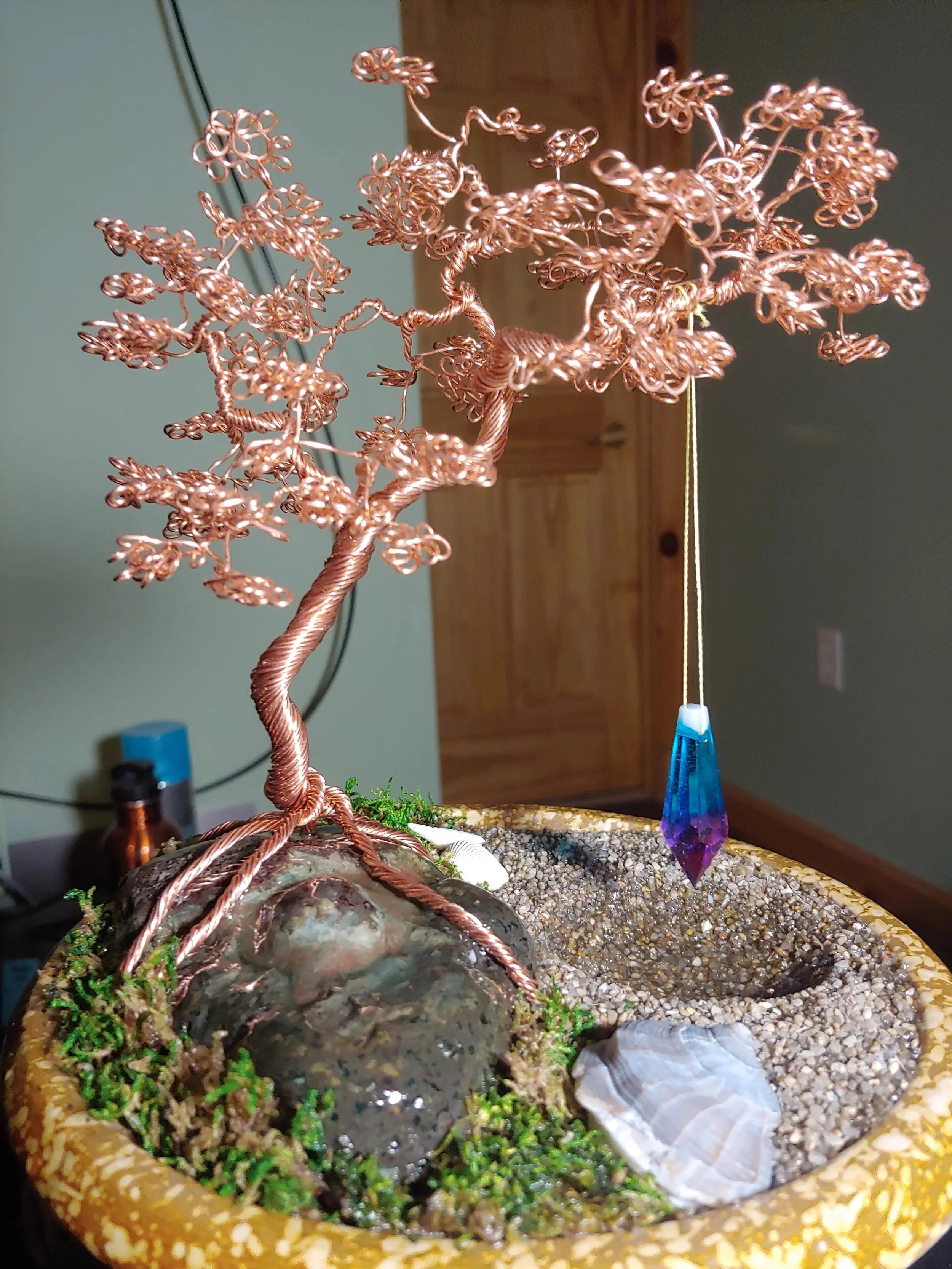 copper wire tree with pendent in a ceramic bowl