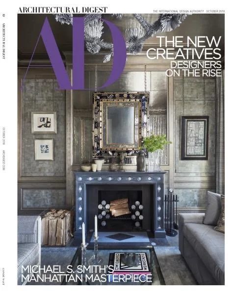 Cover of Architectural Digest magazine featuring a stylish living room with a blue fireplace, decorated mirror, artwork, and modern furniture.