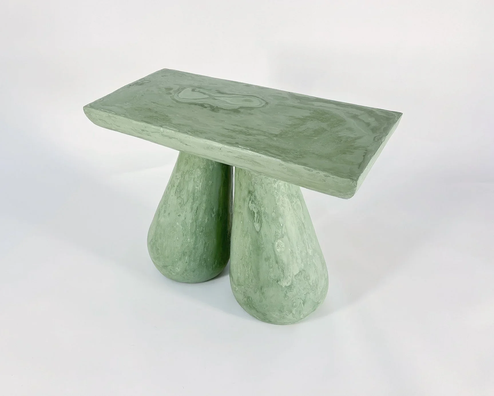 Green marble side table with a rectangular top and three rounded, irregularly shaped legs.