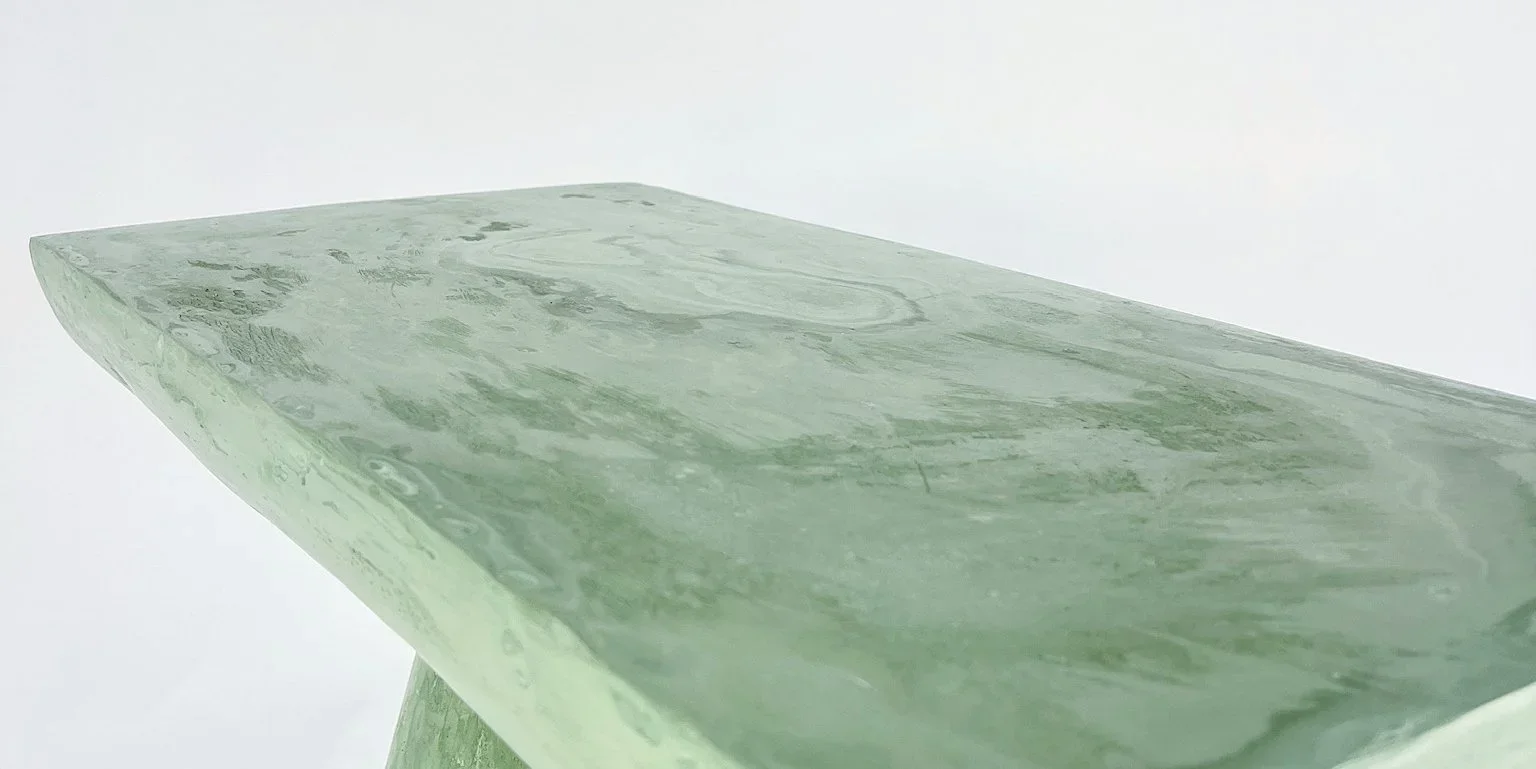 Close-up of a marble or jade-like stone with green and white swirls.