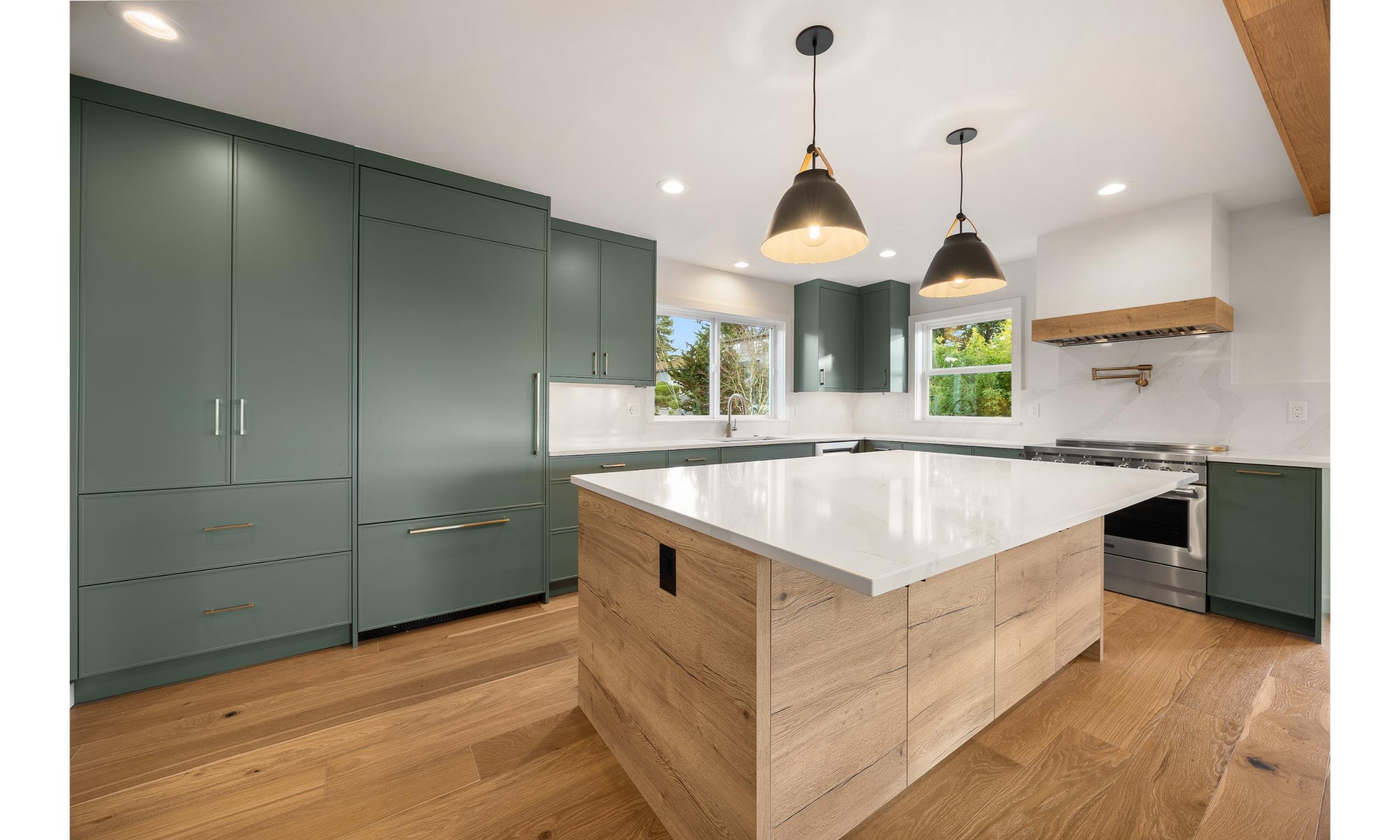 Modern kitchen renovation with white and oak island and custom green cabinetry