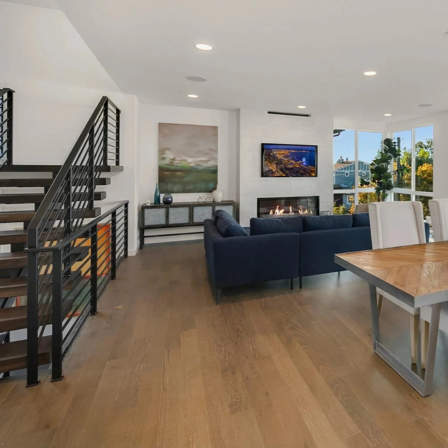 Steel staircase, fireplace and open living room and dining room new construction