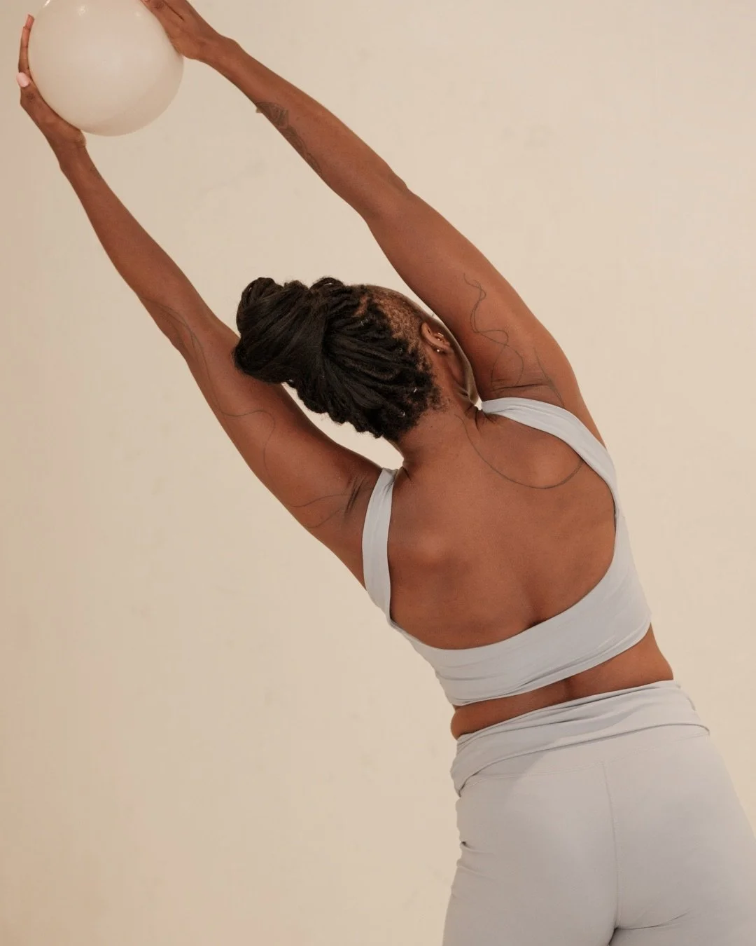 Pilates practitioner demonstrating a lateral arm reach — foundational anatomy, biomechanics, and exercise science course for Pilates instructors