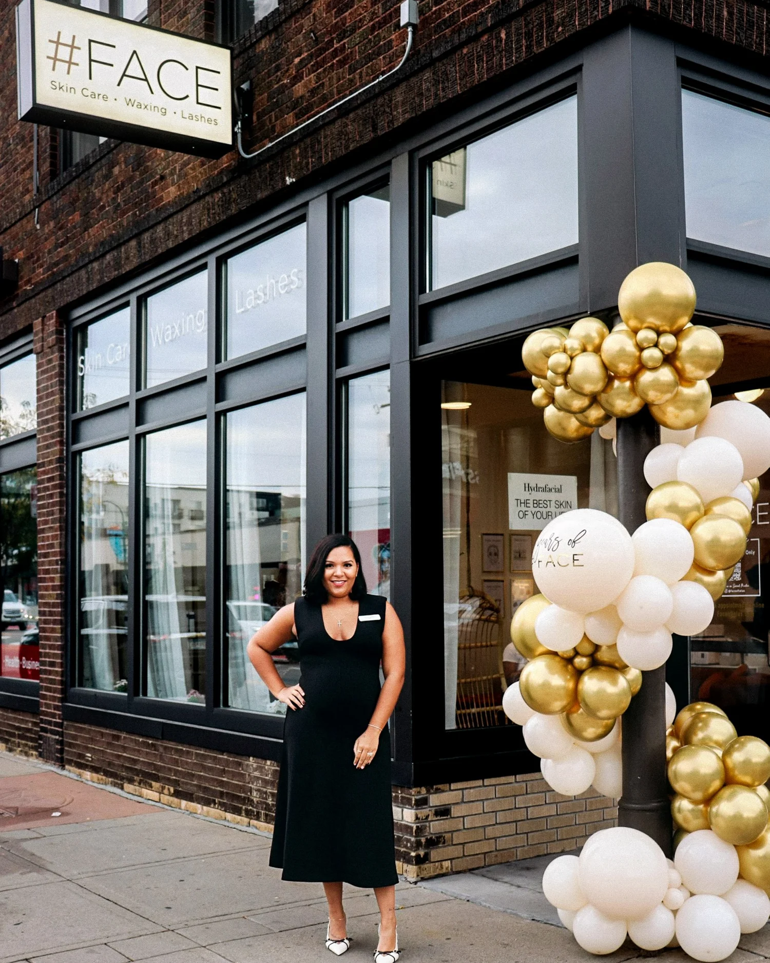 Woman in black dress outside the #FACE storefront
