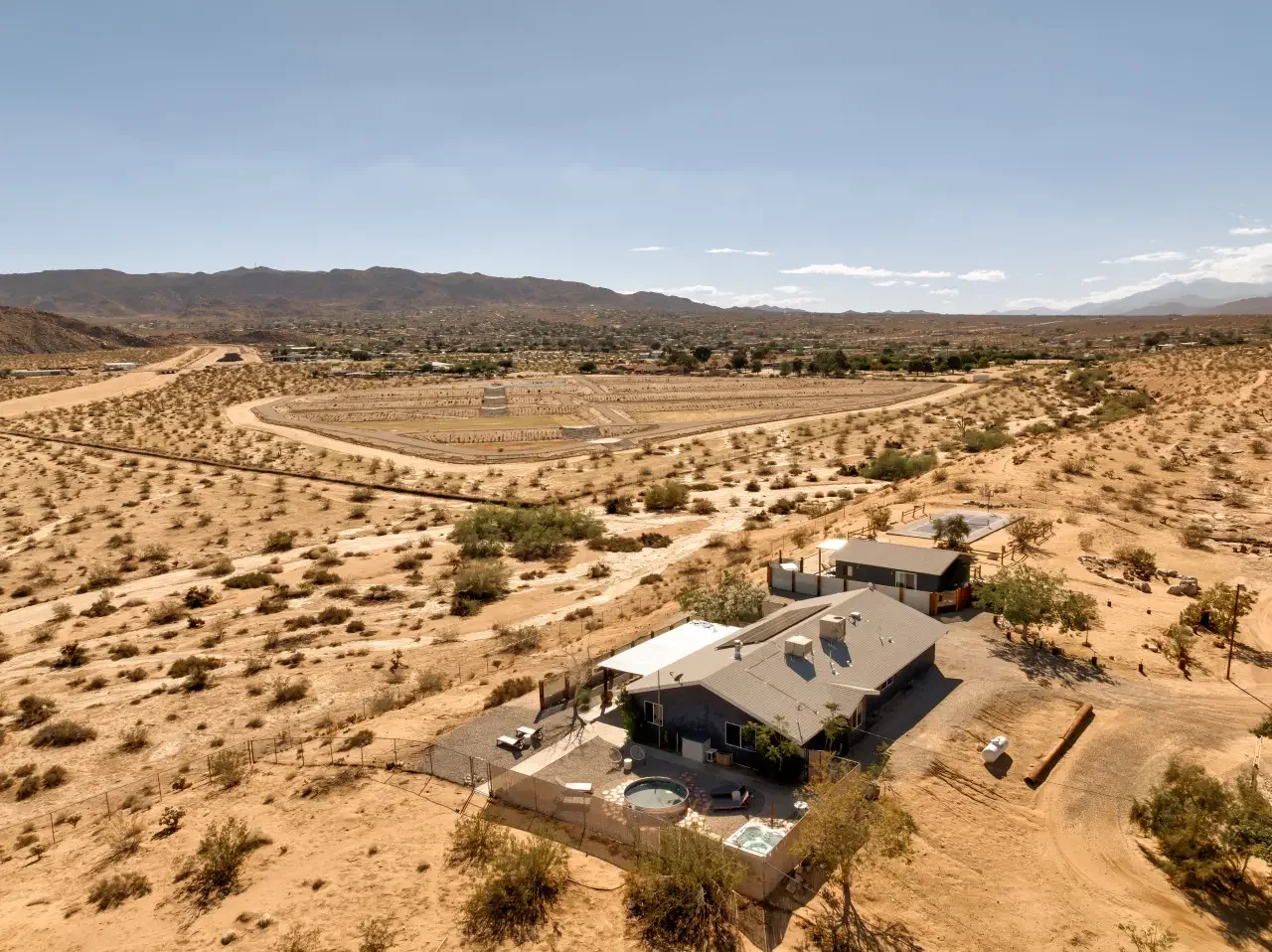 A house with a backyard hot tub located in a desert landscape.
