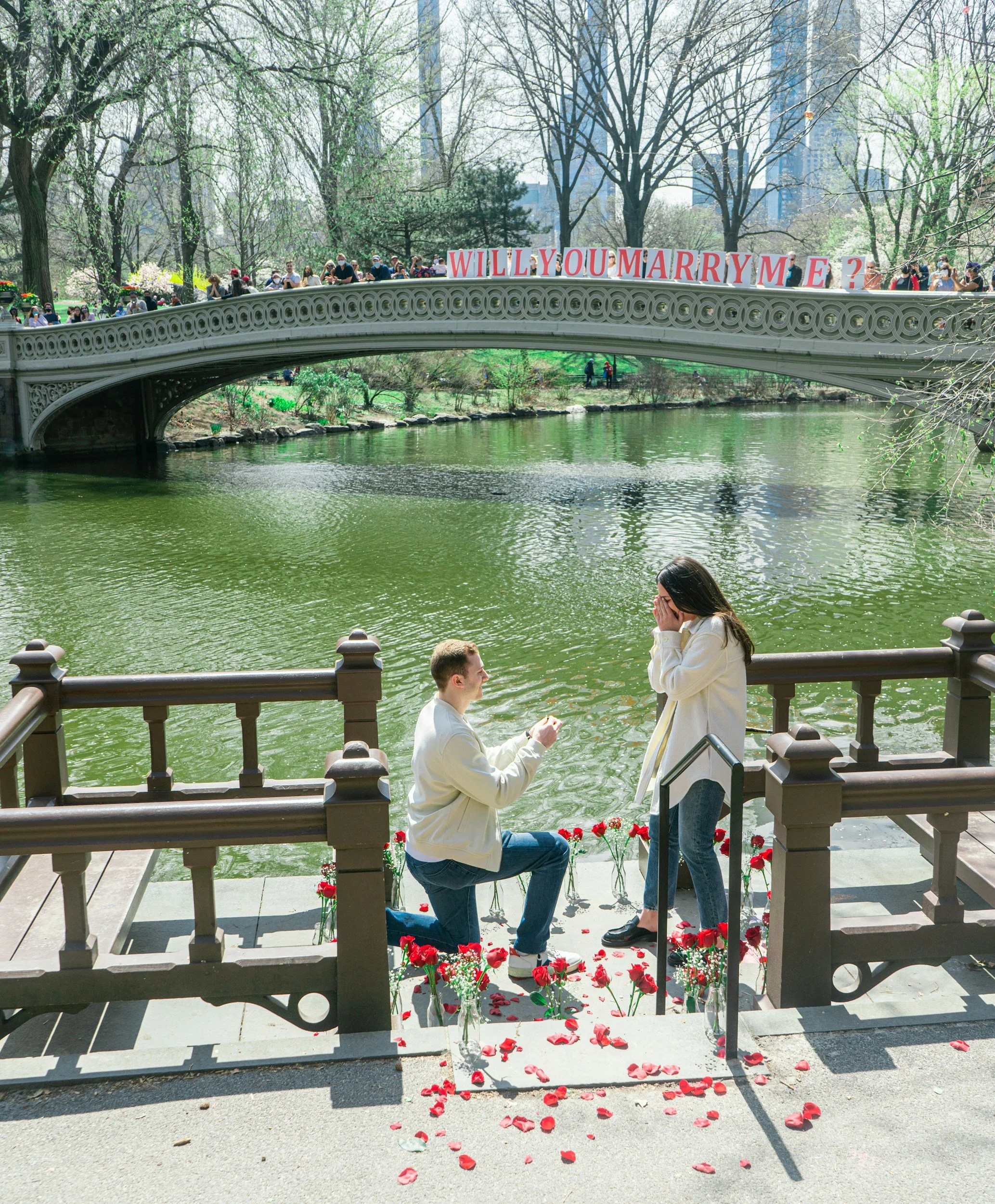 Savannah Cerizo of Luna Solis Live proposal venue on a bridge. Romantic proposal setting with "WILL YOU MARRY ME" sign. Available for surprise engagements and proposals.