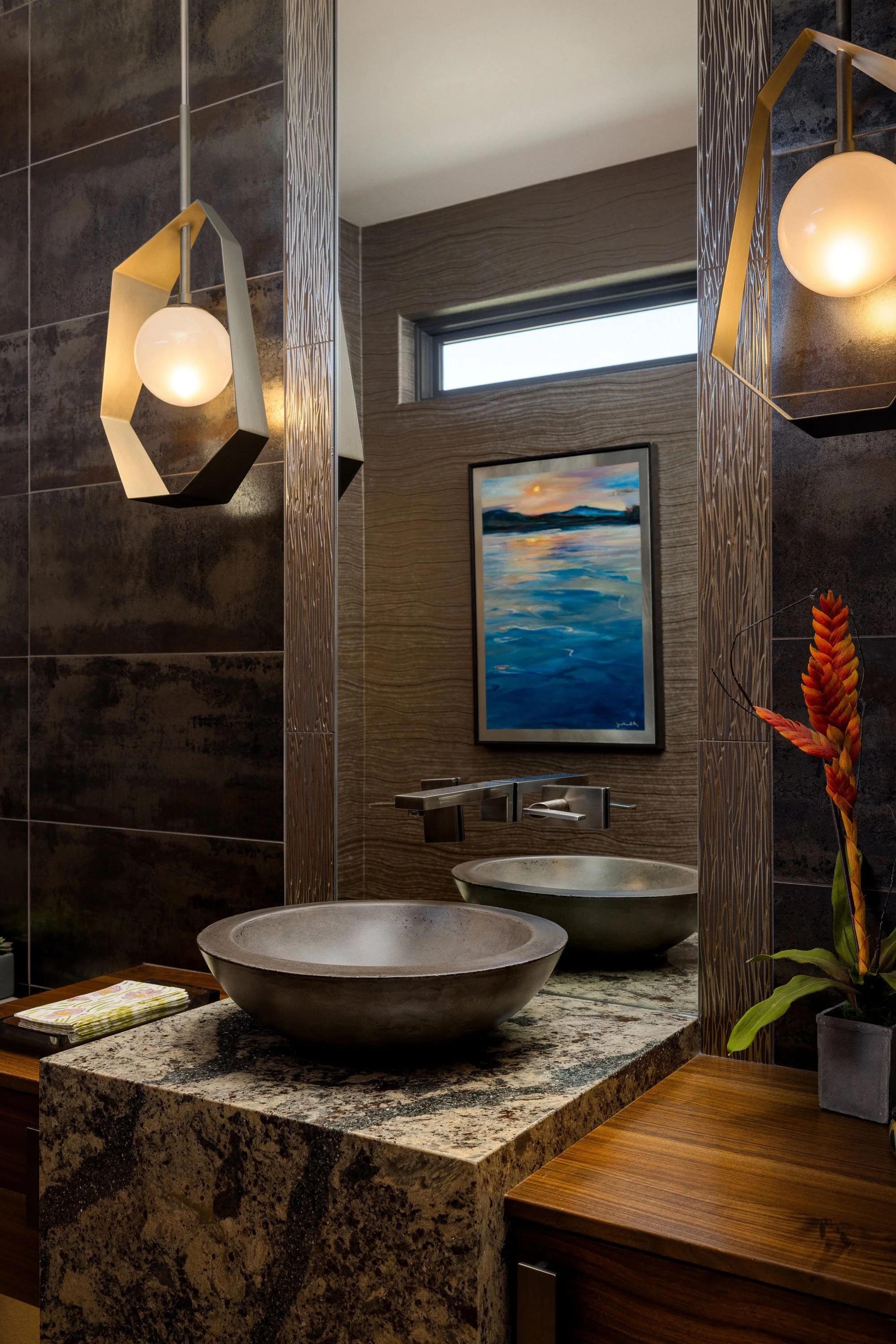 A modern vanity sink with dark, natural materials.