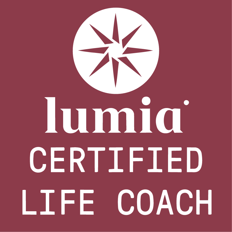 A logo with a dark pink background, featuring a black circular emblem with a starburst design. Below the emblem, the text reads "lumia" in lowercase letters, and underneath that, it says "CERTIFIED LIFE COACH" in uppercase letters.
