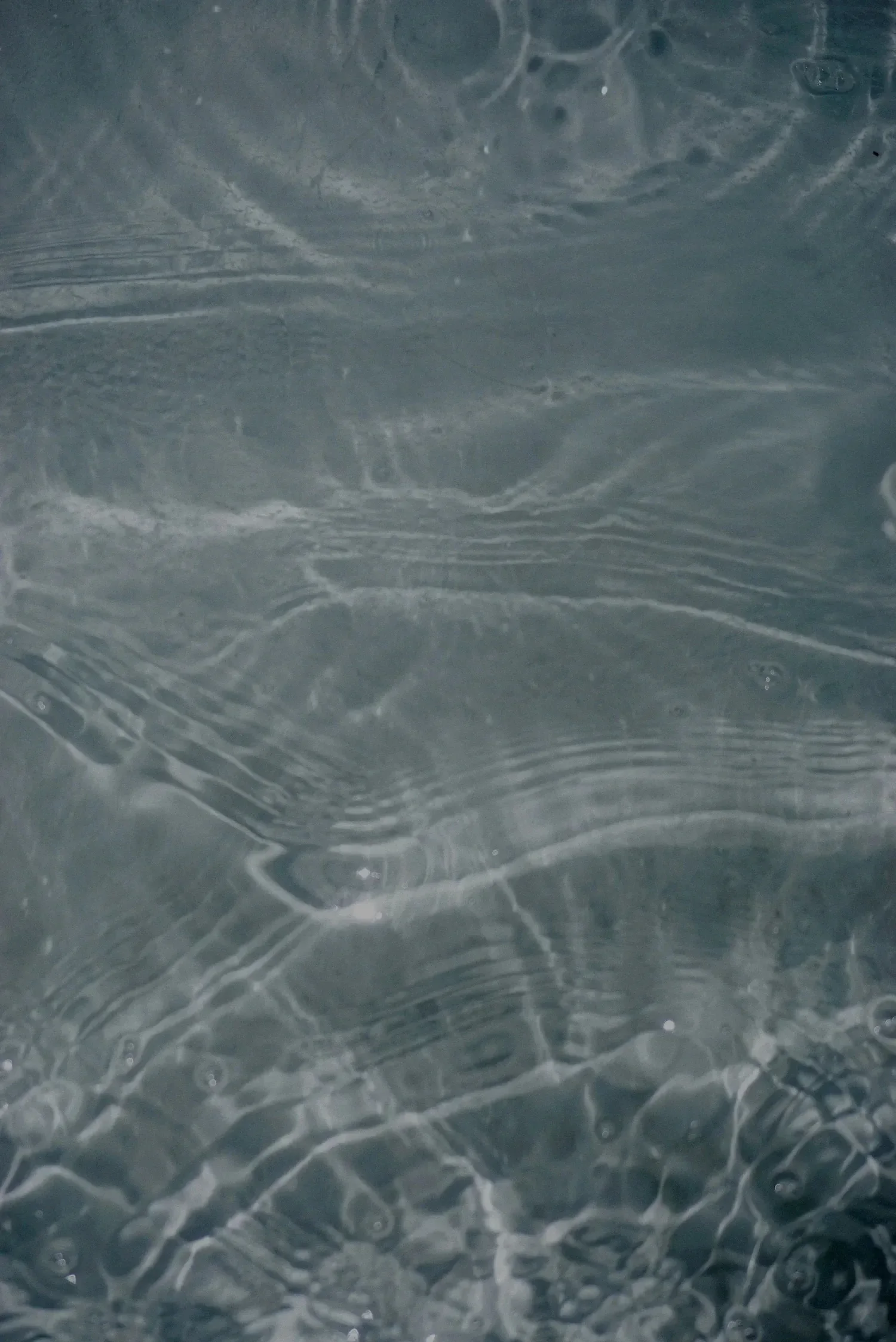 Close-up of water with ripples and bubbles on the surface.