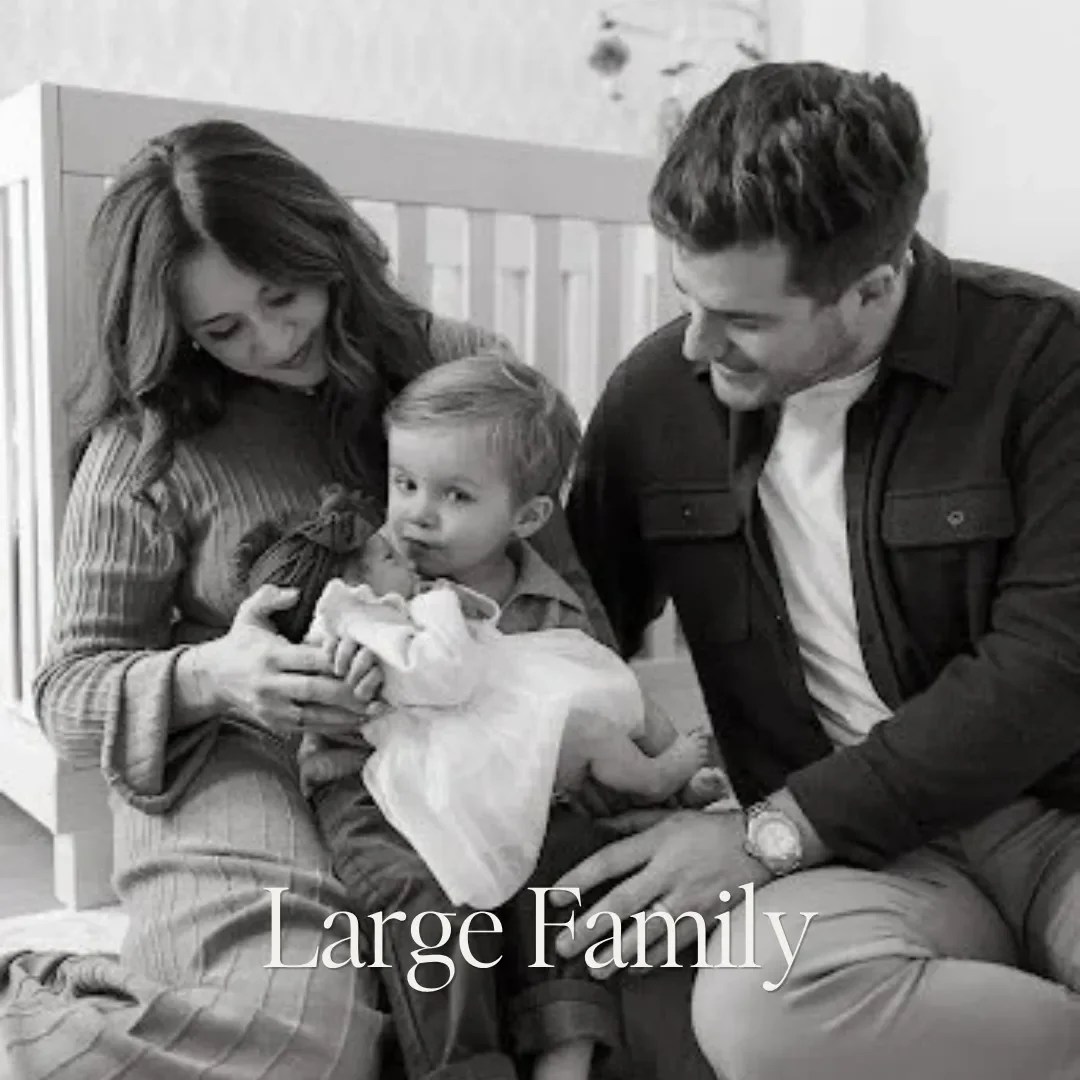 A family of four sitting on the floor, with a woman holding a newborn baby, a young boy looking at the camera, and a man smiling at the baby. The text overlay reads 'Large Family'.