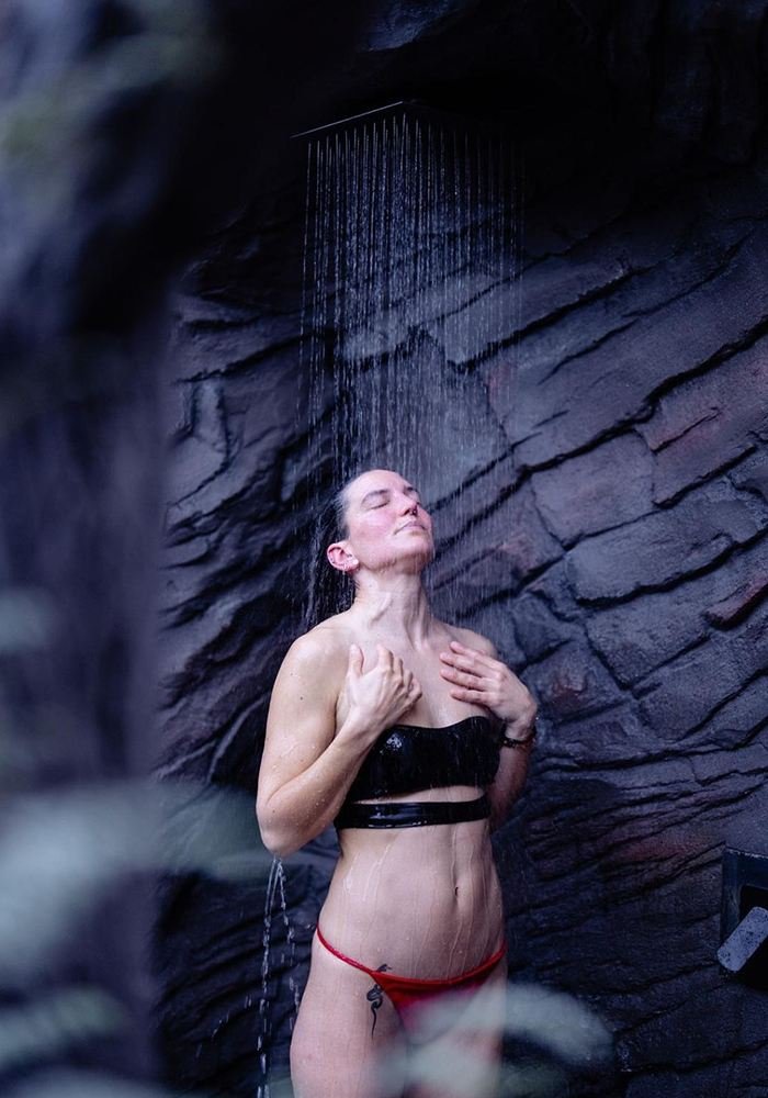 Guest under the outdoor cold shower beside the cold plunge at Pure Senses, Cromwell