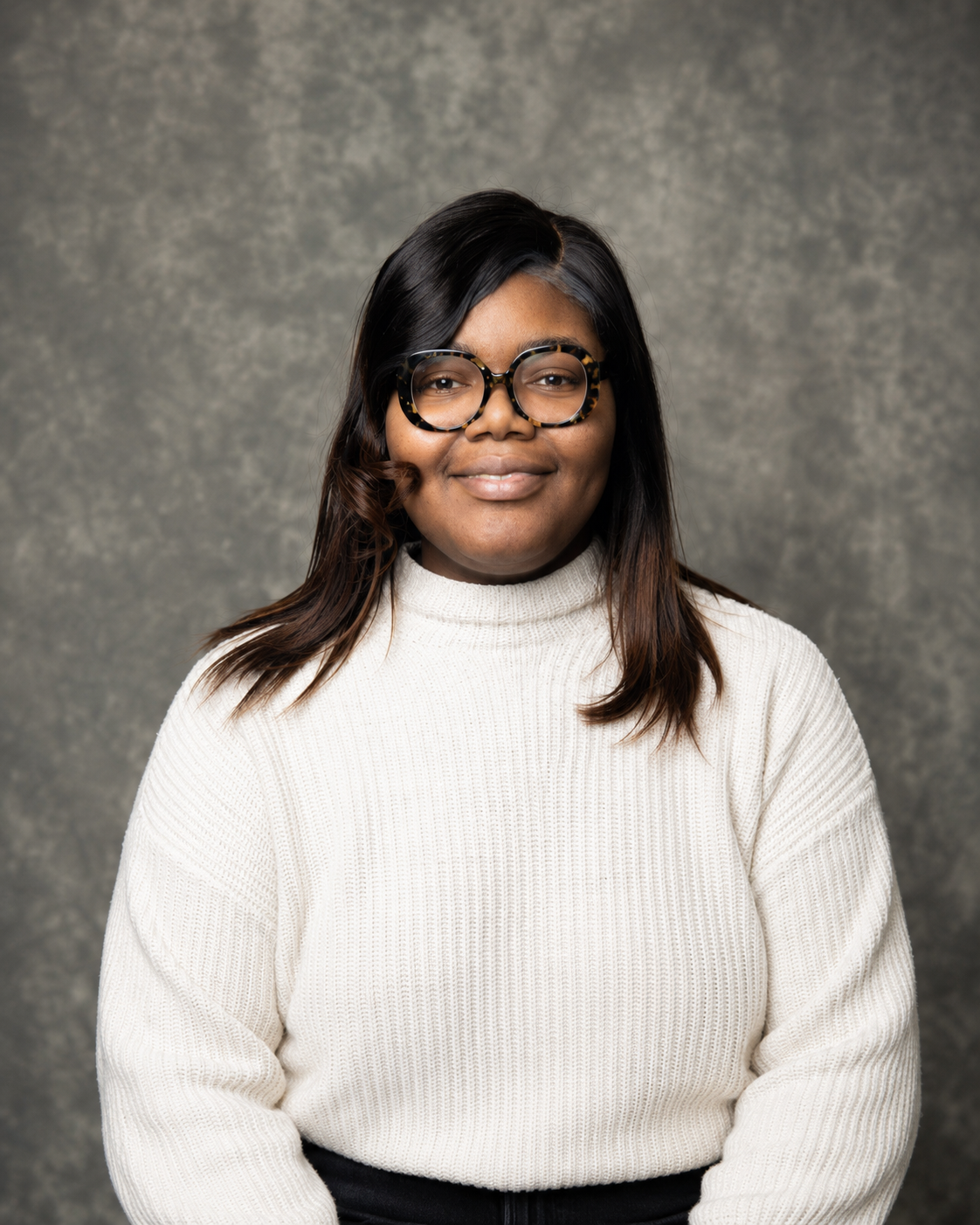 Black women who is in her mid twenties pursuing clinical psychology. A child of immigrants who hopes to improve the lives of children