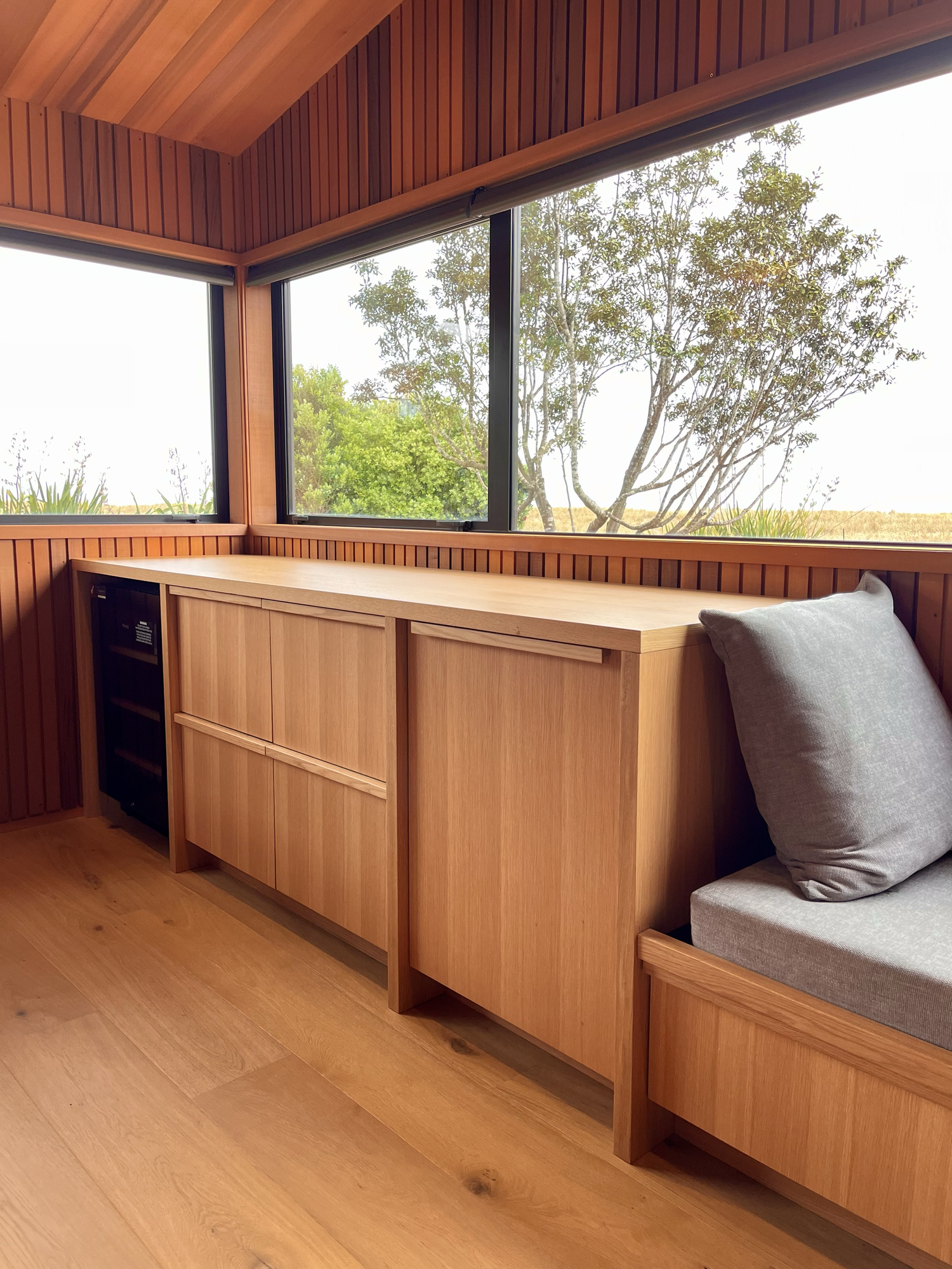 Oak Window Seat & Bar with integrated wine fridge and moulded oak handles / Kūaotunu, 2025.