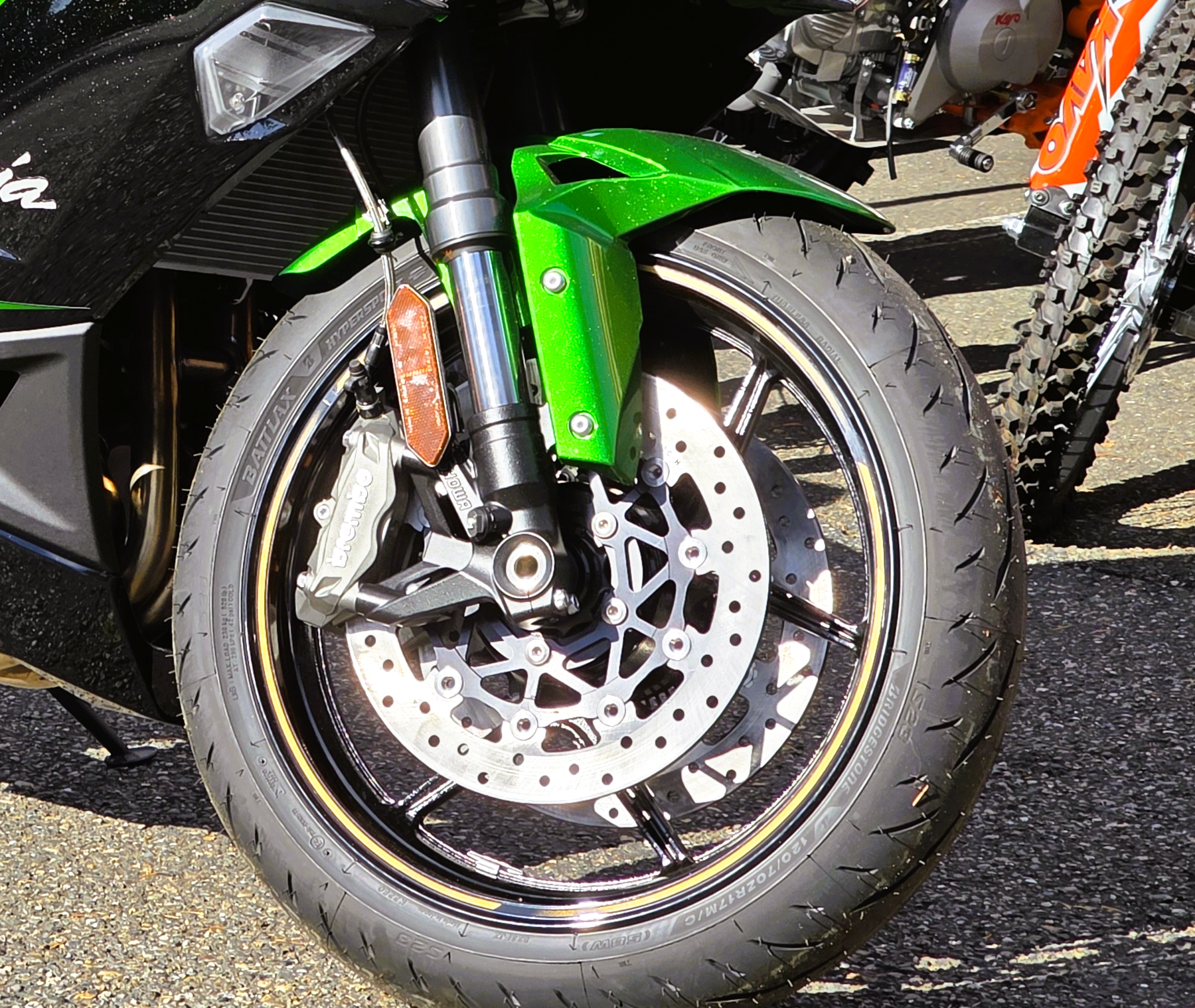 Close-up of a motorcycle's front wheel, disc brake, and suspension after having new tires installed at DFD Cycles in Kitsap County Washinton.