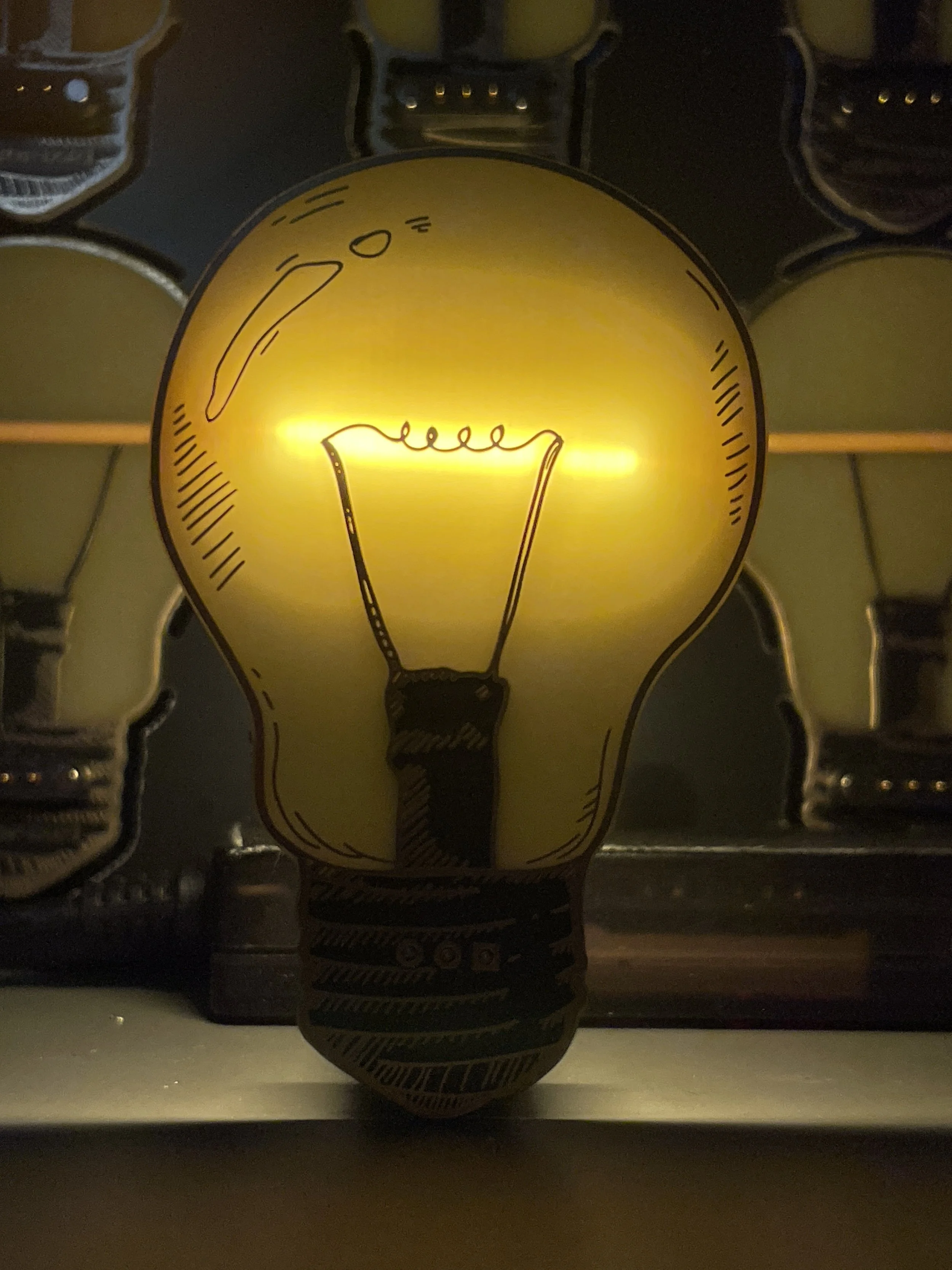 Close-up photo of a yellow lightbulb pcb with a drawn filament,