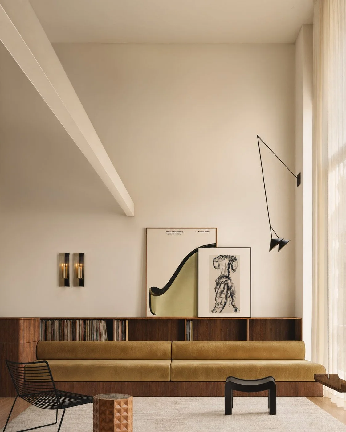 Loft living room with tan velvet banquette below walnut record shelving, brass sconces and a black wire chair