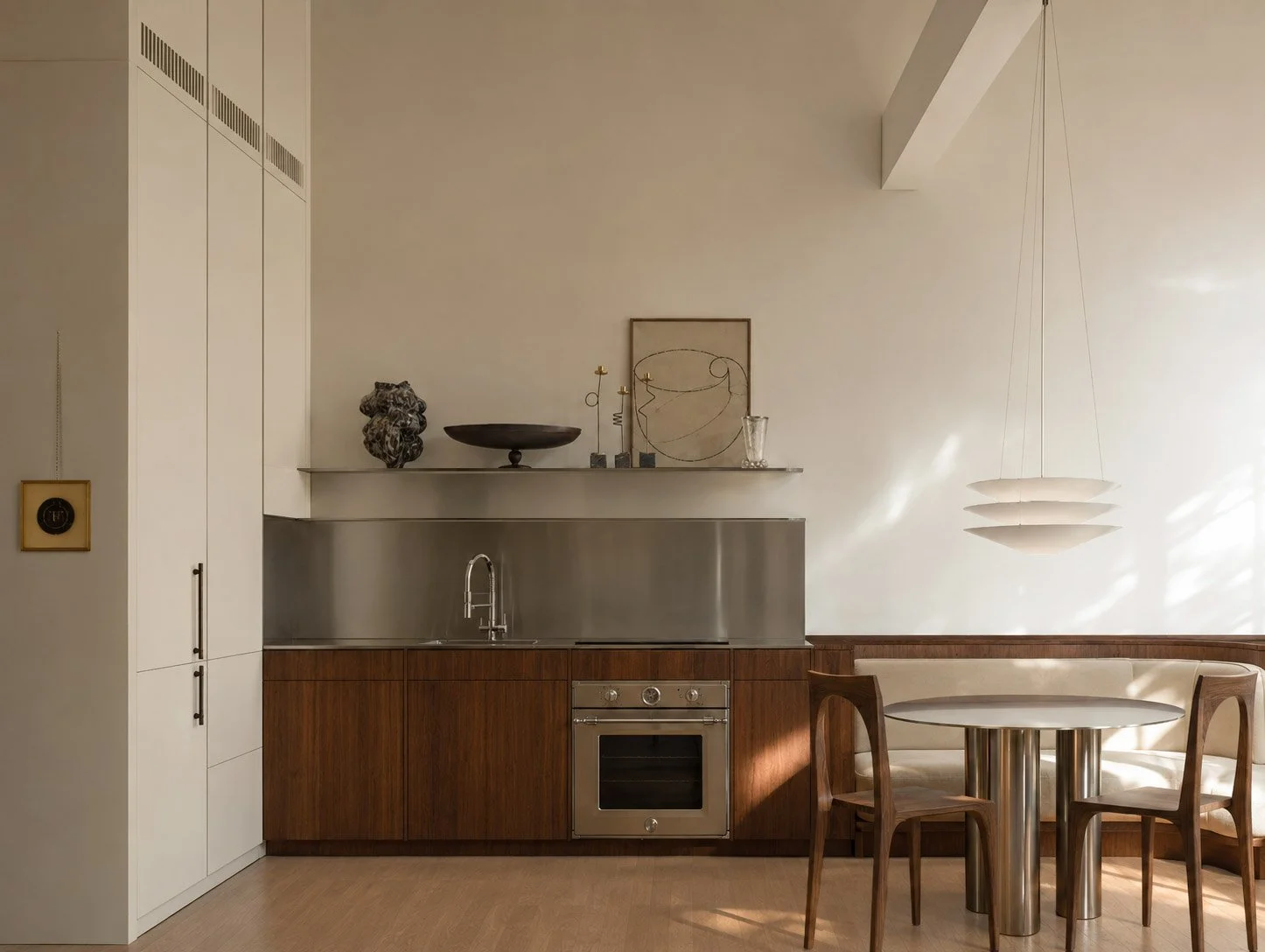 Sky Loft kitchen and dining with walnut joinery, stainless steel surfaces and a curved banquette