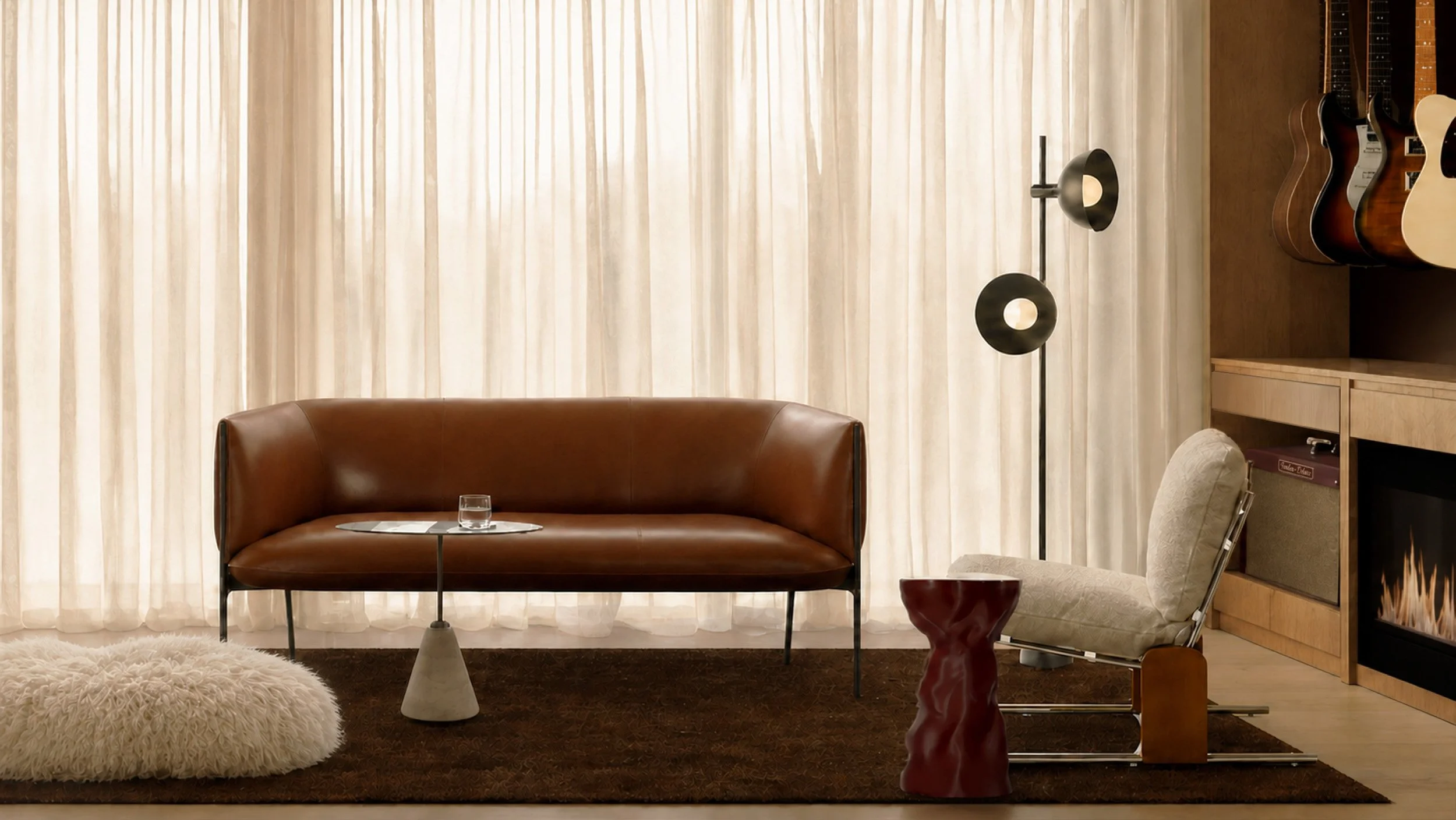 Music room with a tan leather sofa, guitar wall and fireplace on a deep brown rug