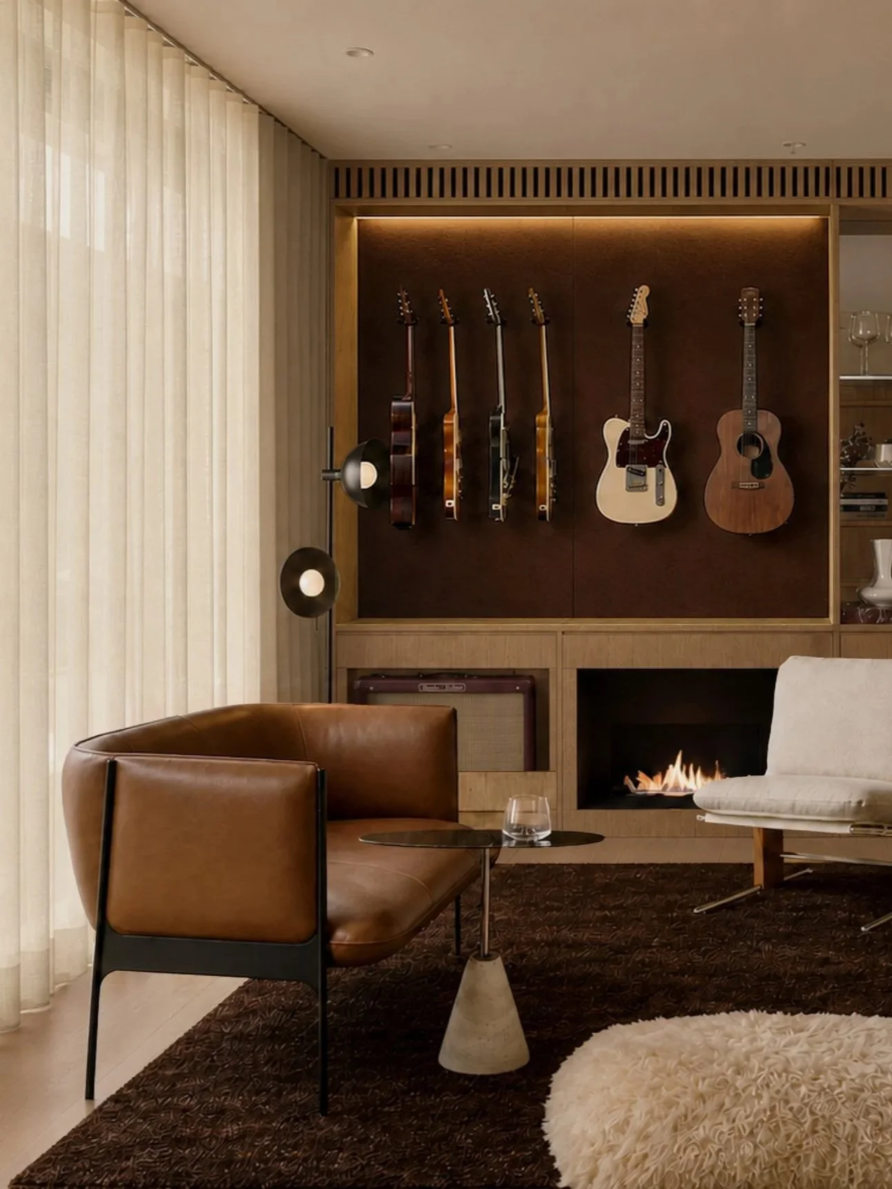 The music room seen from the hallway, guitars and fireplace framed by oak joinery