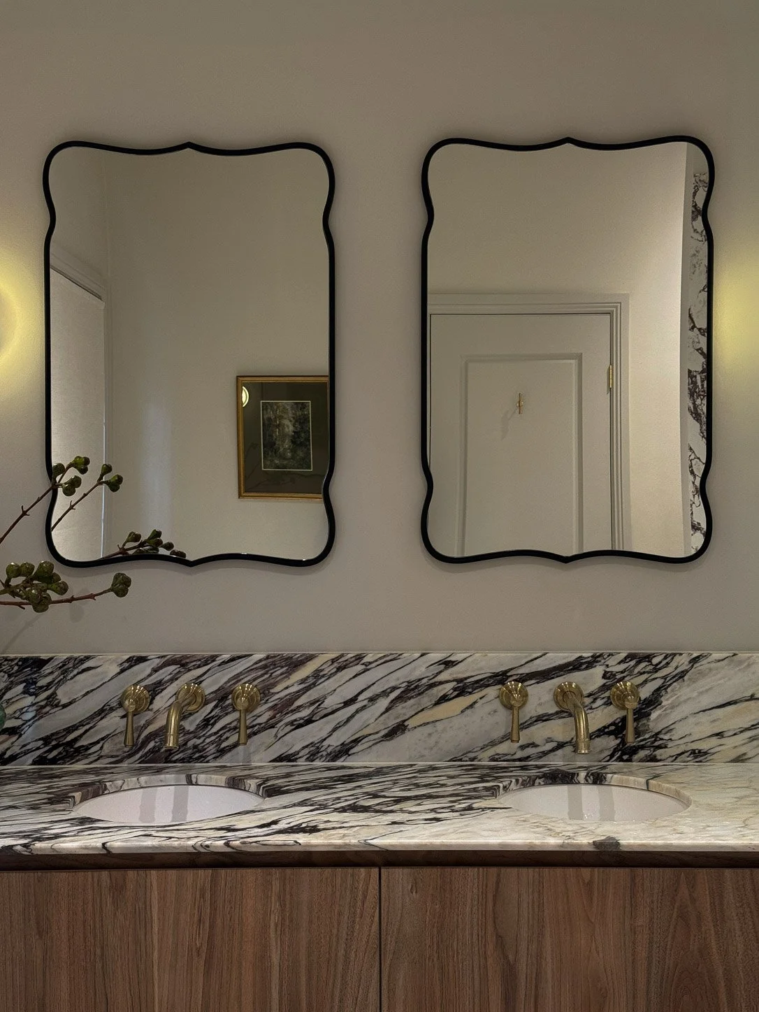 Ensuite with twin wavy black-framed mirrors above a Calacatta Monet double vanity in walnut