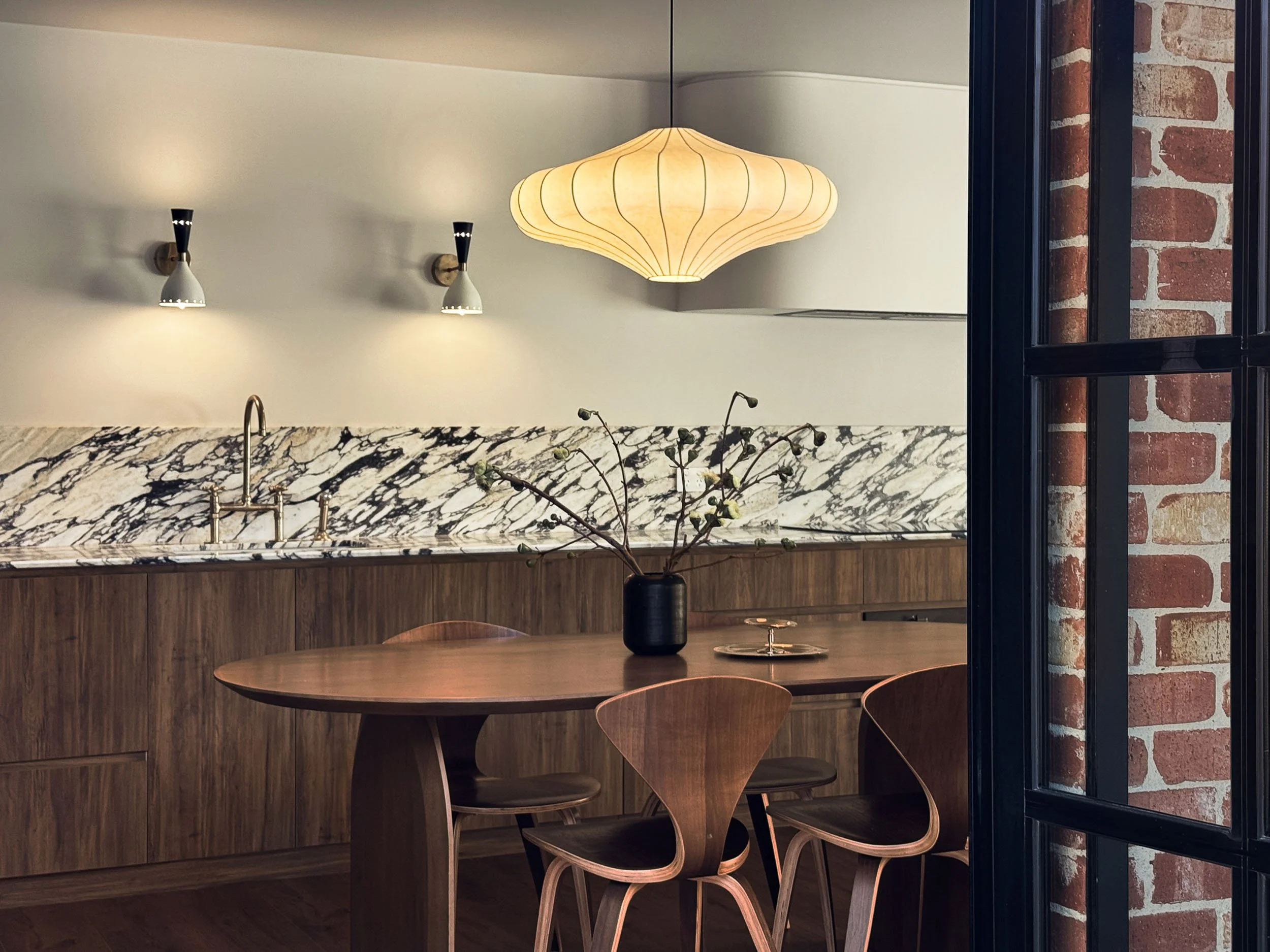 Kitchen and dining with Calacatta Monet splashback, brass bridge tap and walnut cabinetry
