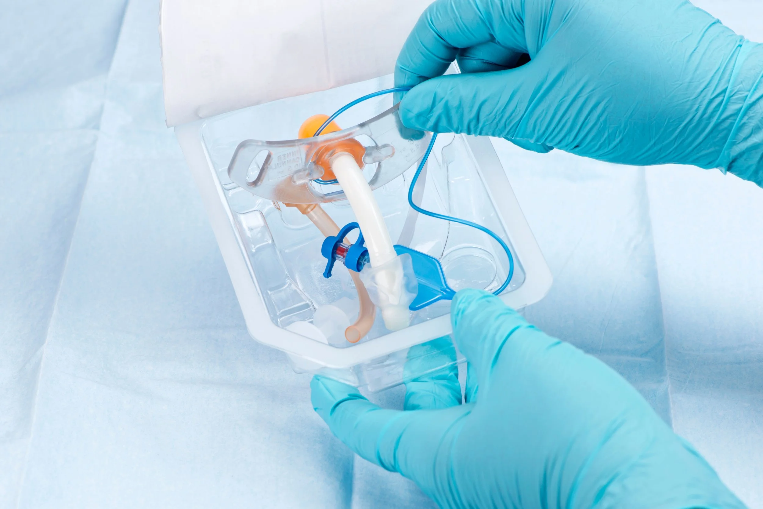 Close-up of a medical professional wearing blue gloves inserting a tube into a biological specimen container, with a blue background.