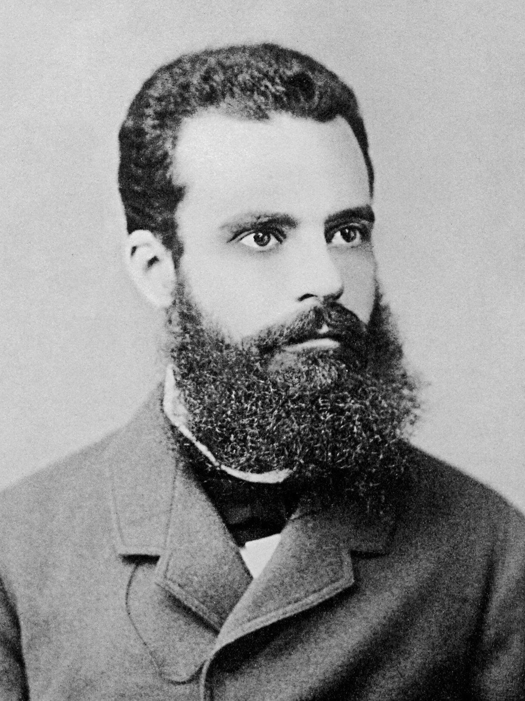 Black and white portrait of Vilfredo Pareto, a man with a full beard, mustache, and short hair, wearing a coat and a shirt, looking to the side.