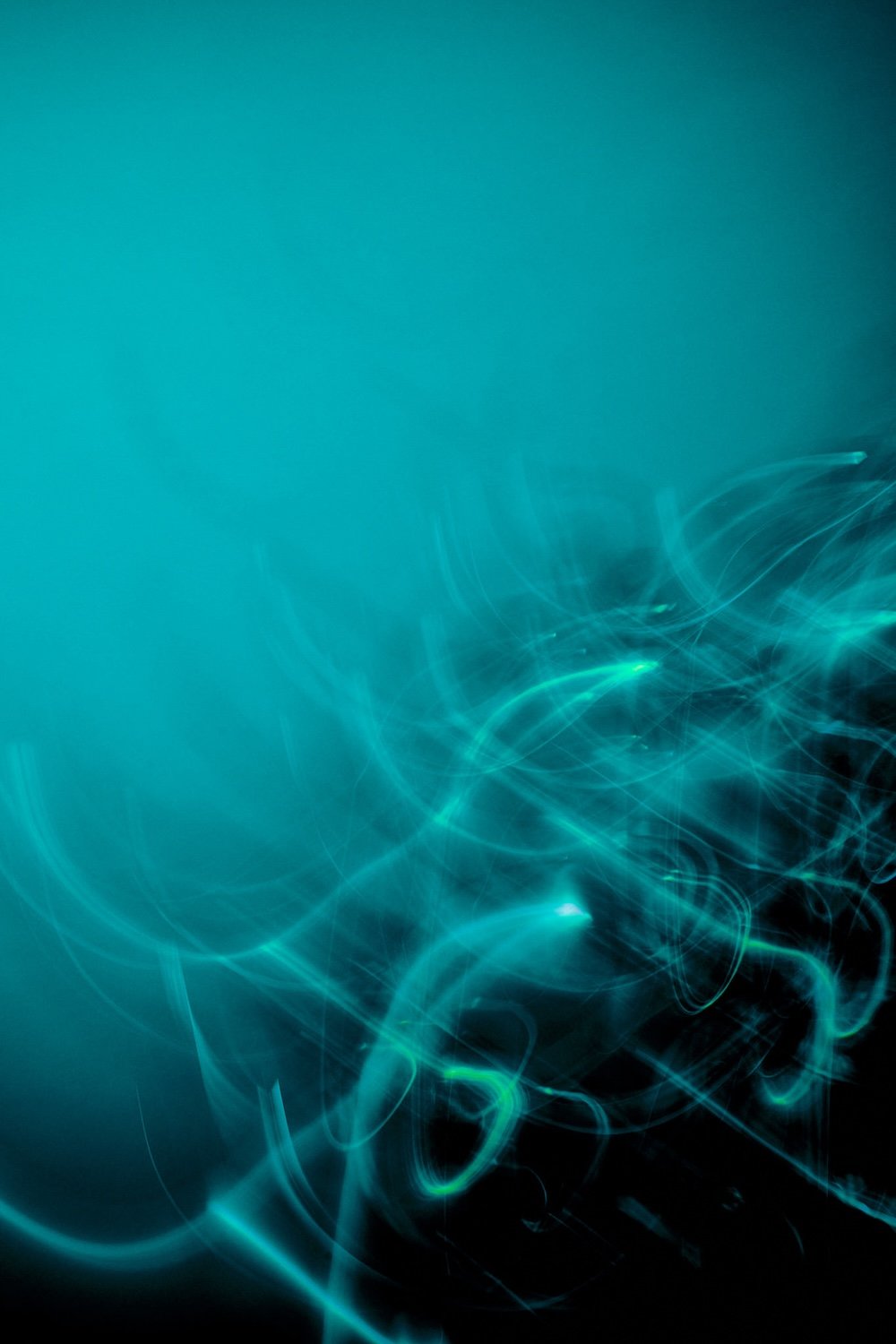 Design abstrato com linhas de luz azul e verde sobre fundo escuro do catálogo Spectra Nova
