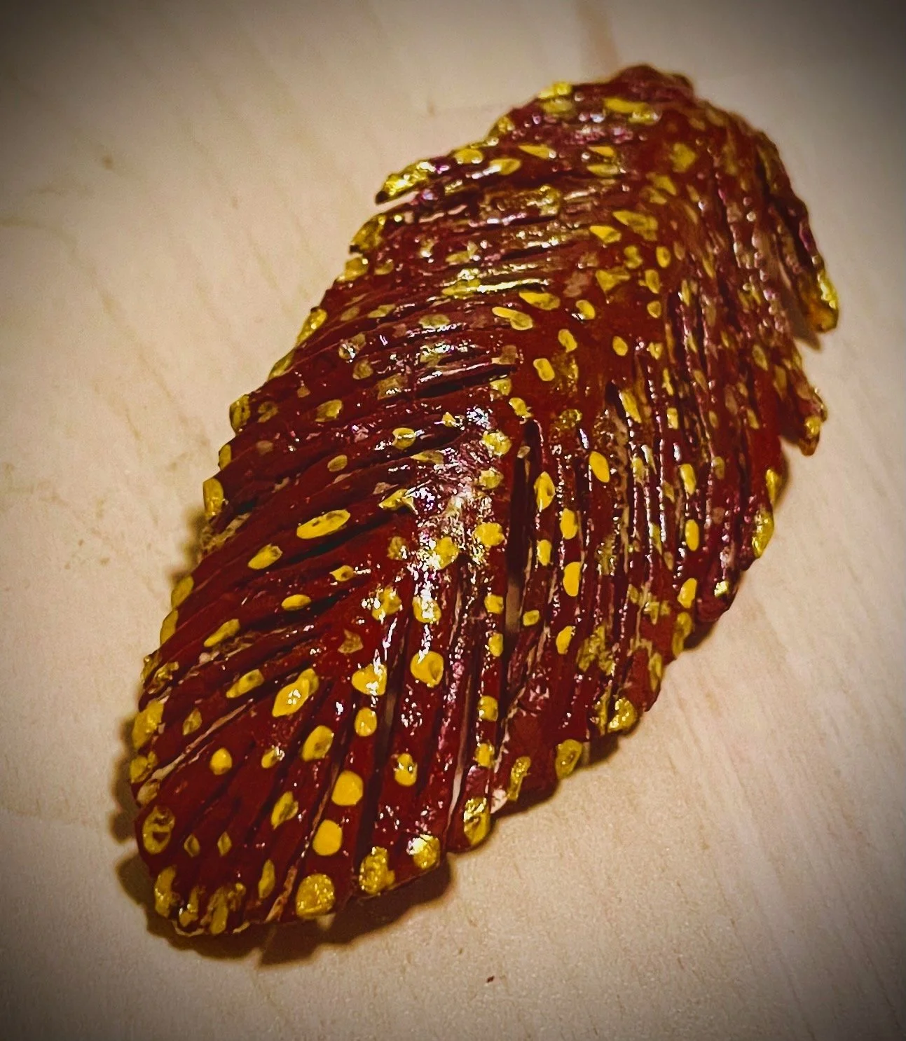 Close-up of a sliced citrus rind with yellow colored mustard seeds on top, placed on a light-colored surface.