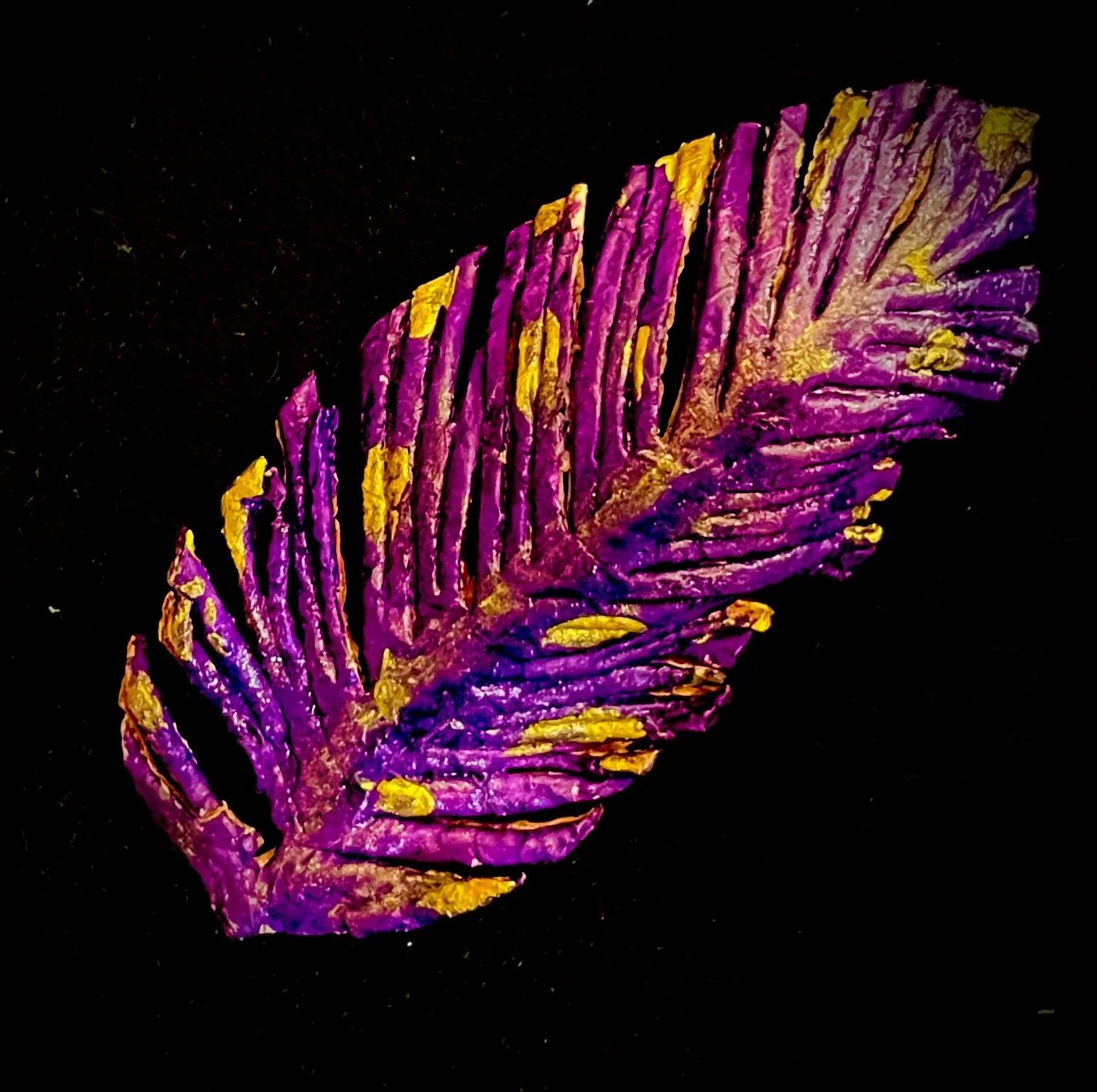 Close-up of a colorful citrus rind with purple, yellow, and pink hues against a black background.