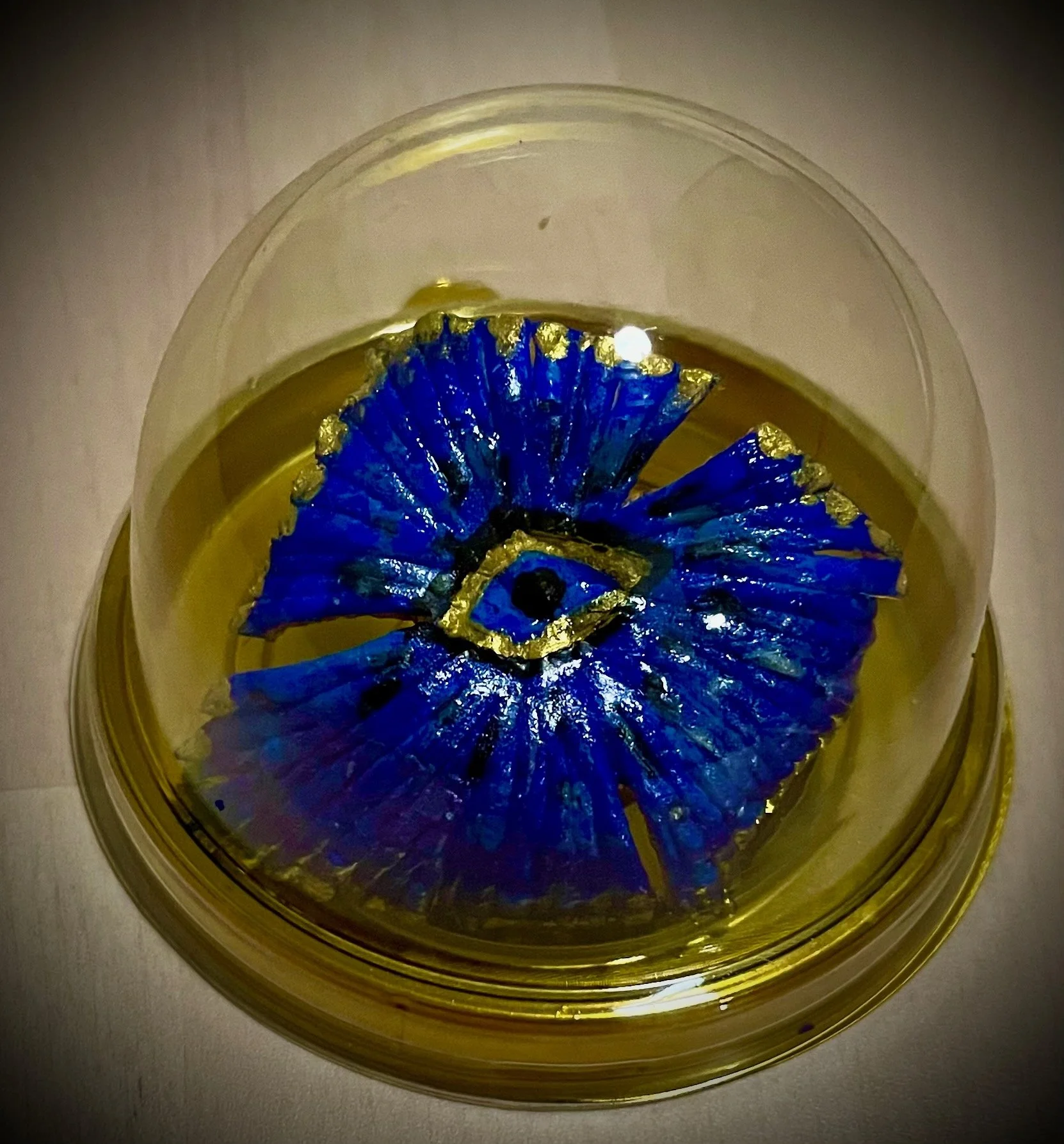 Top view of a citrus rind with a blue flower and gold accents.